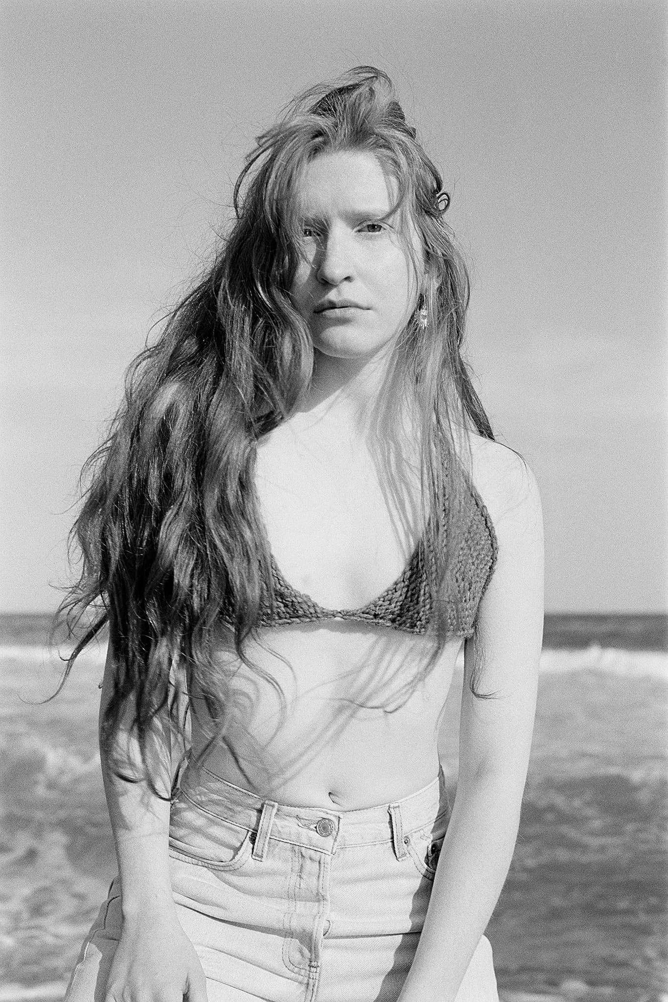 Woman in knit bikini top at the beach, black and white portrait.
