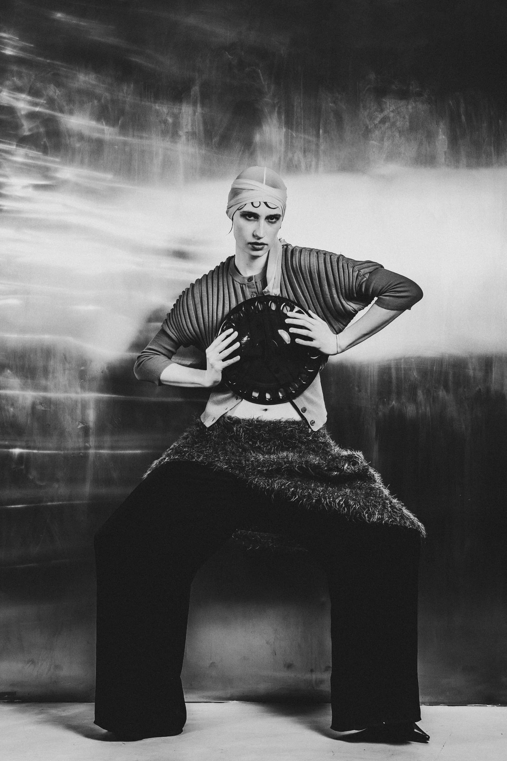 Avant-garde fashion pose in dramatic black and white photography.