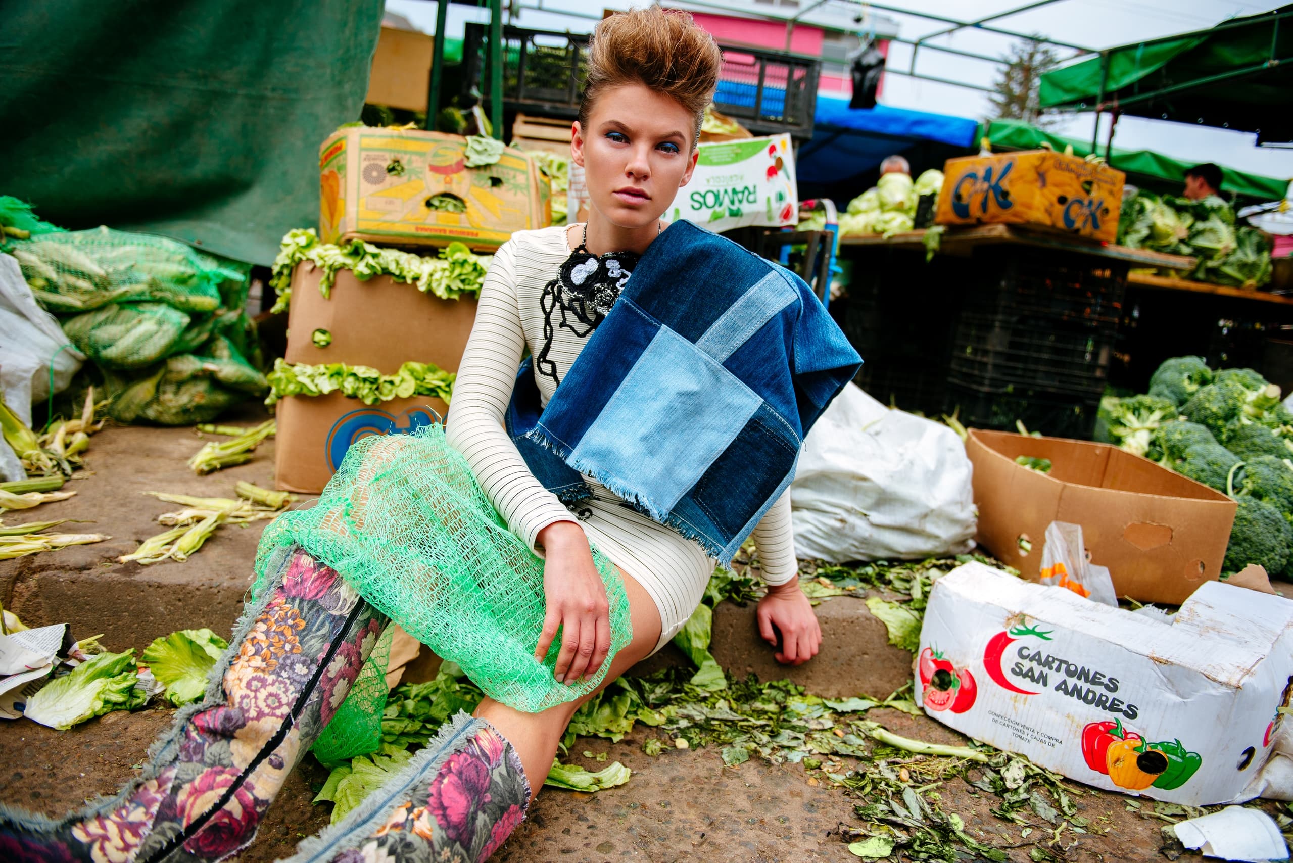 Fashionable model in a vibrant market setting, wearing eclectic, colorful attire.