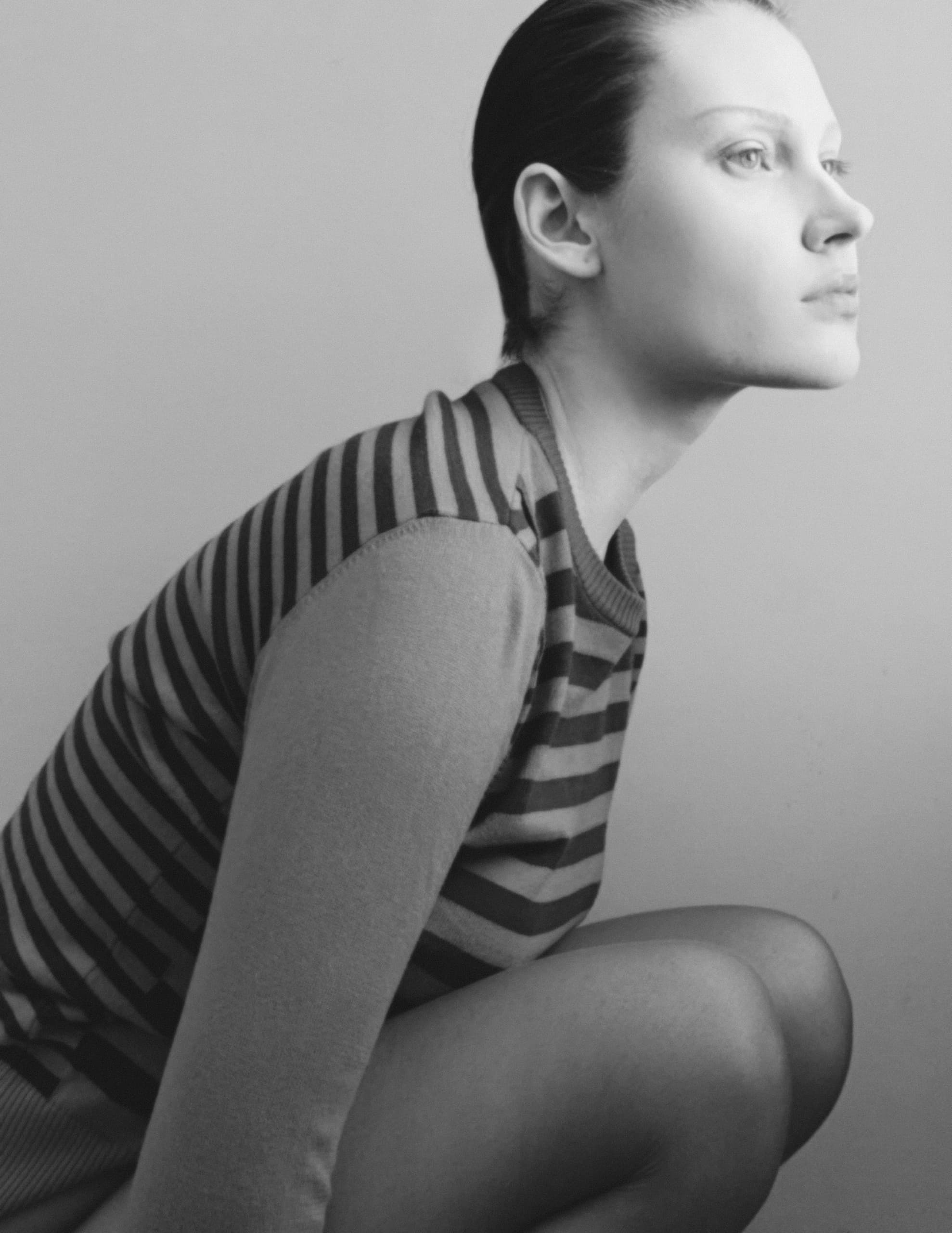 Profile of person in striped sweater in monochrome photography.