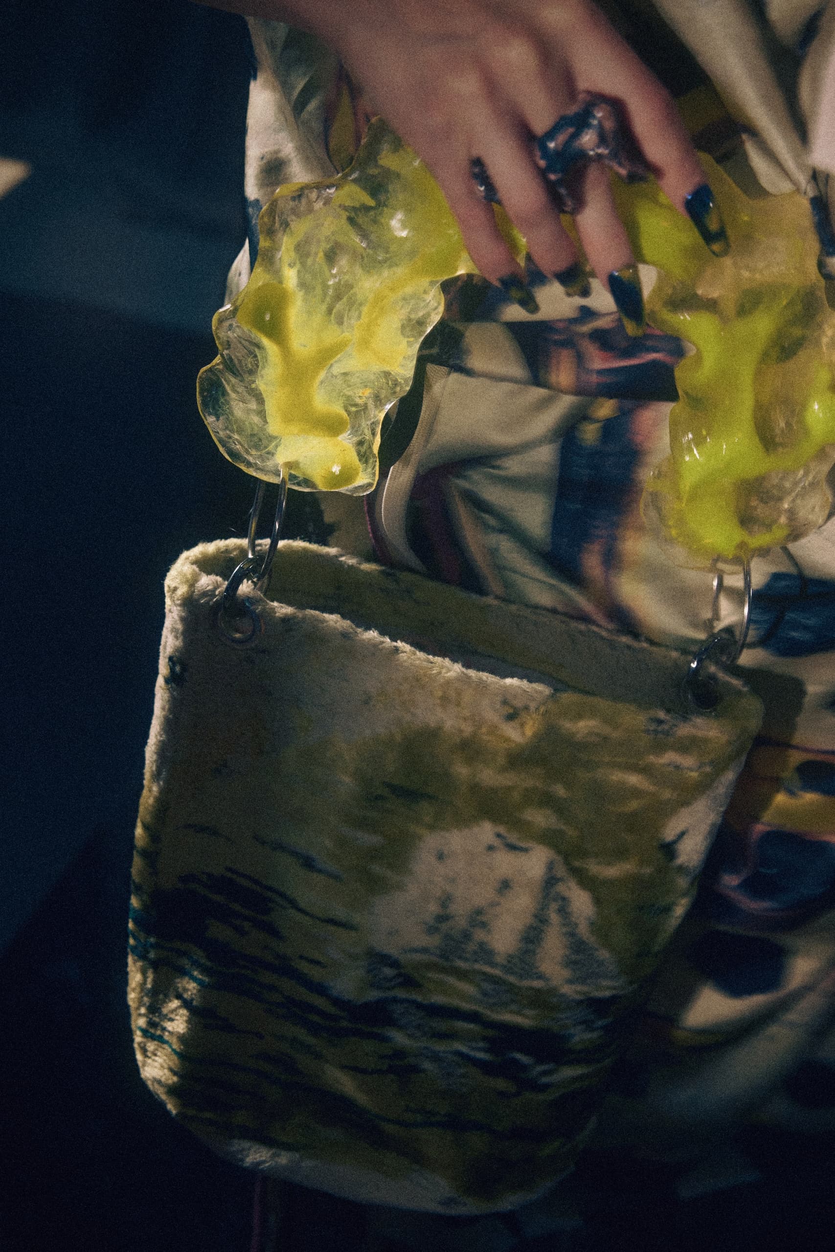 Fashionable tote bag with unique yellow plastic handles in a close-up view.