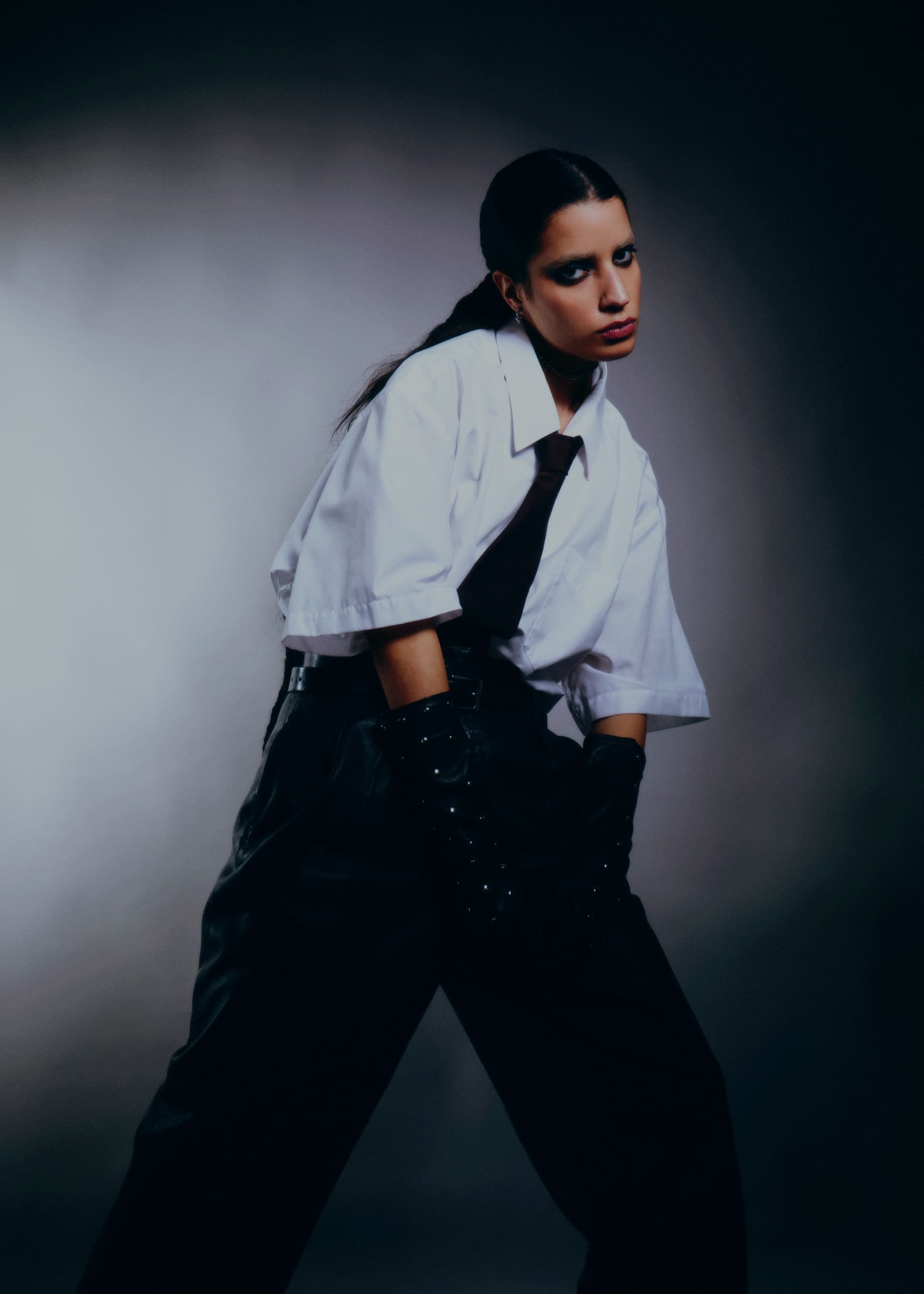 Fashionable woman in a white shirt and tie with edgy style.