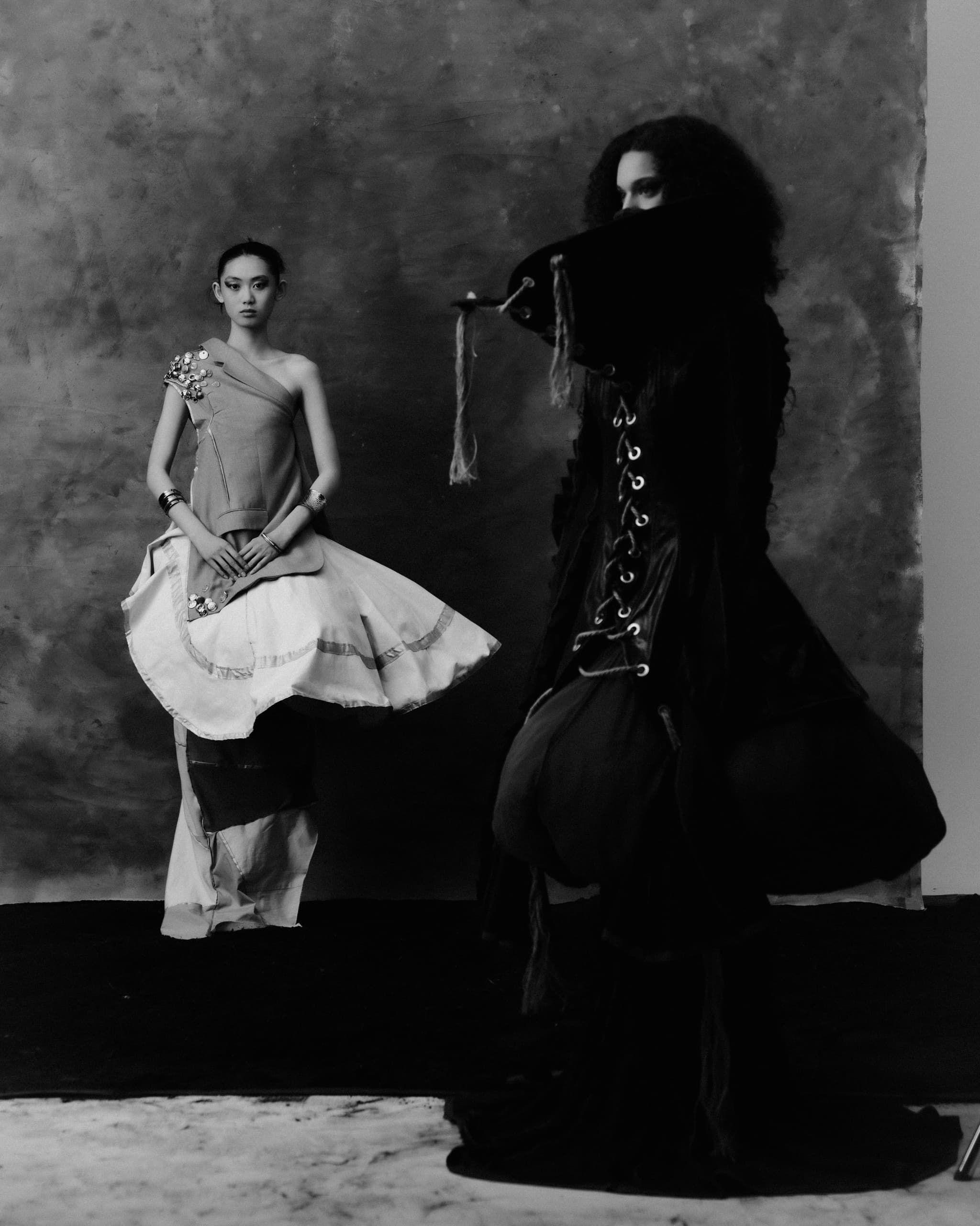 Two models in elegant, artistic fashion, black and white photography.