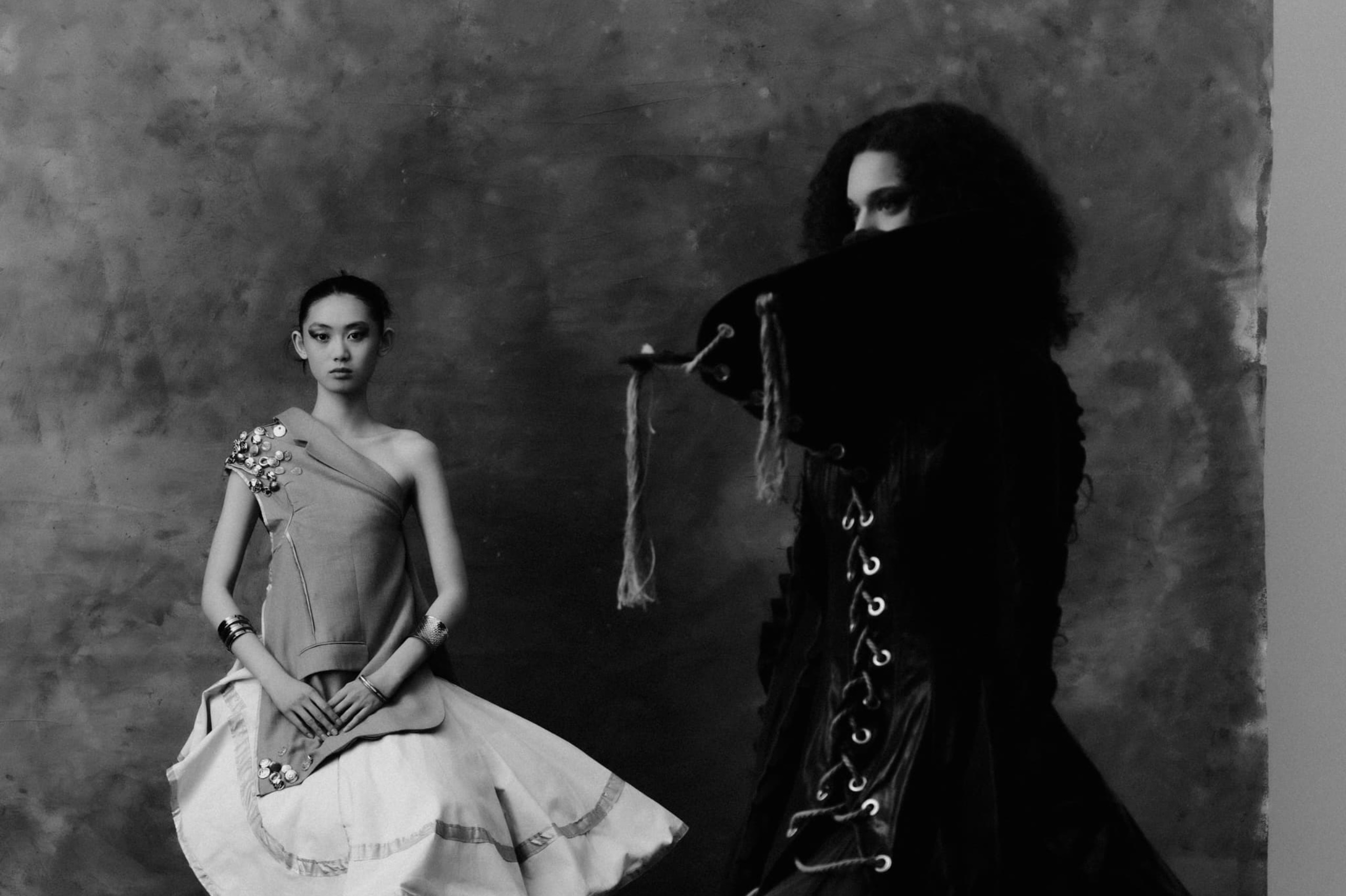 Elegant fashion photoshoot with dramatic outfits, monochrome style.