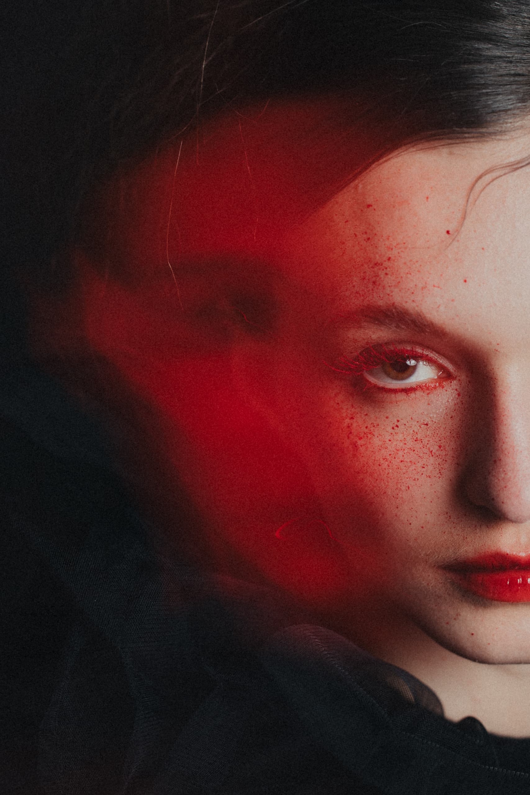 Artistic portrait with red accents and dramatic expression.