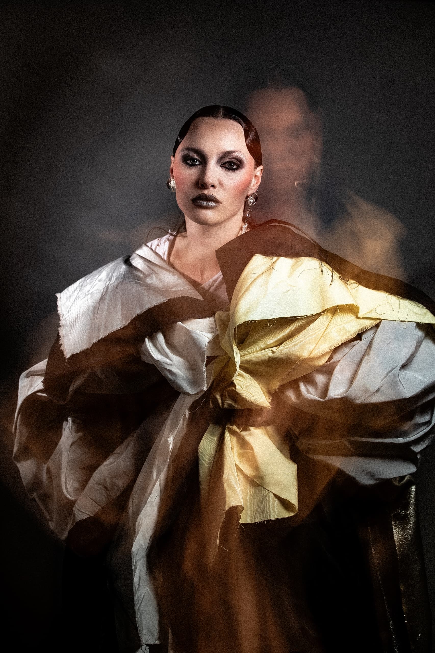 Avant-garde fashion portrait with dramatic lighting and bold makeup.
