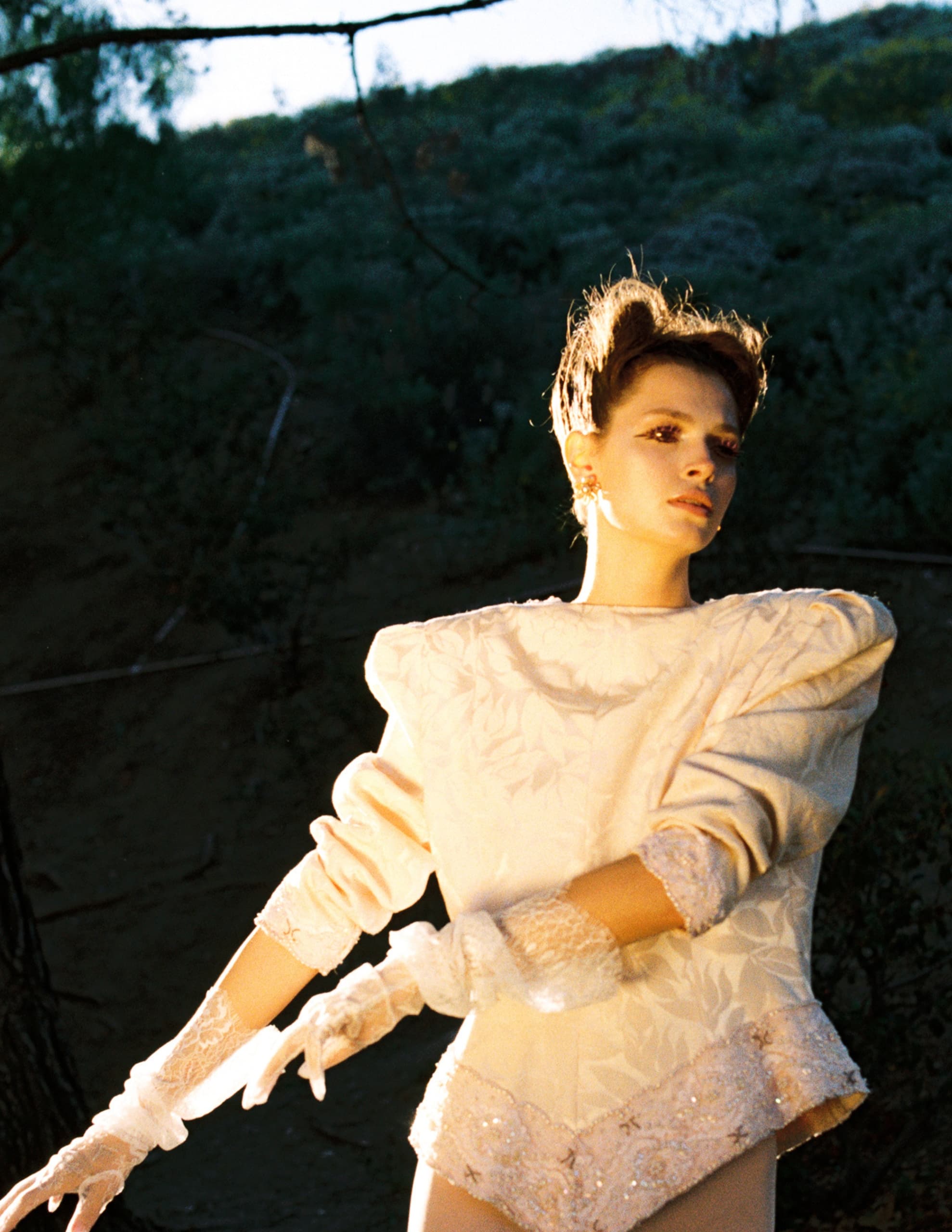 Vintage fashion in nature, person in elegant white attire and lace gloves.