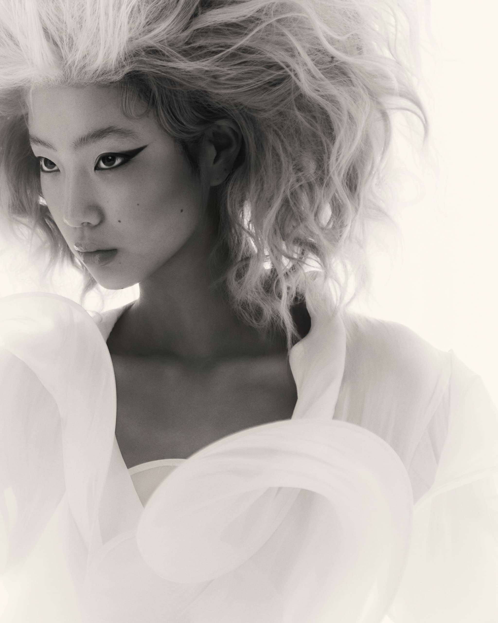 Avant-garde fashion portrait with dramatic hair and makeup.