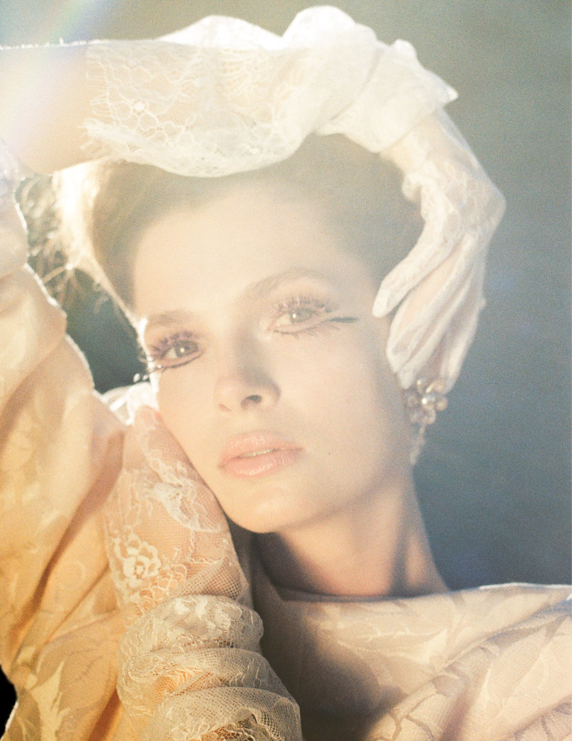 Elegant woman in lace gloves, vintage fashion pose with soft lighting.