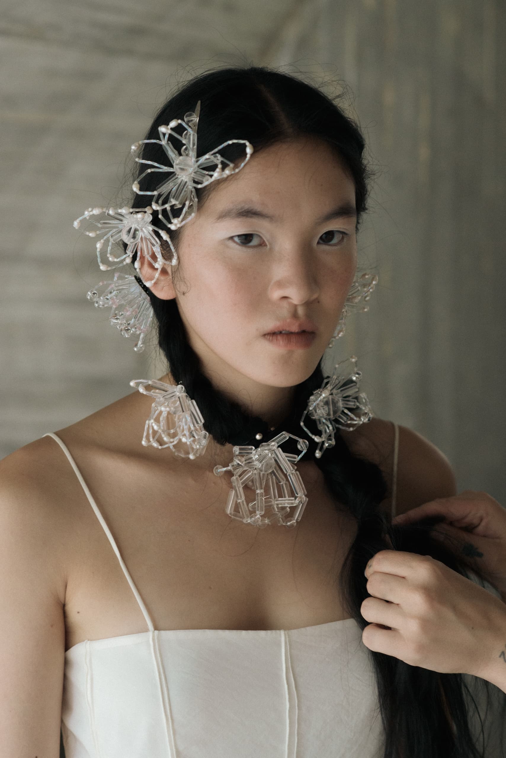 Woman with braided hair adorned with delicate crystal floral accessories.