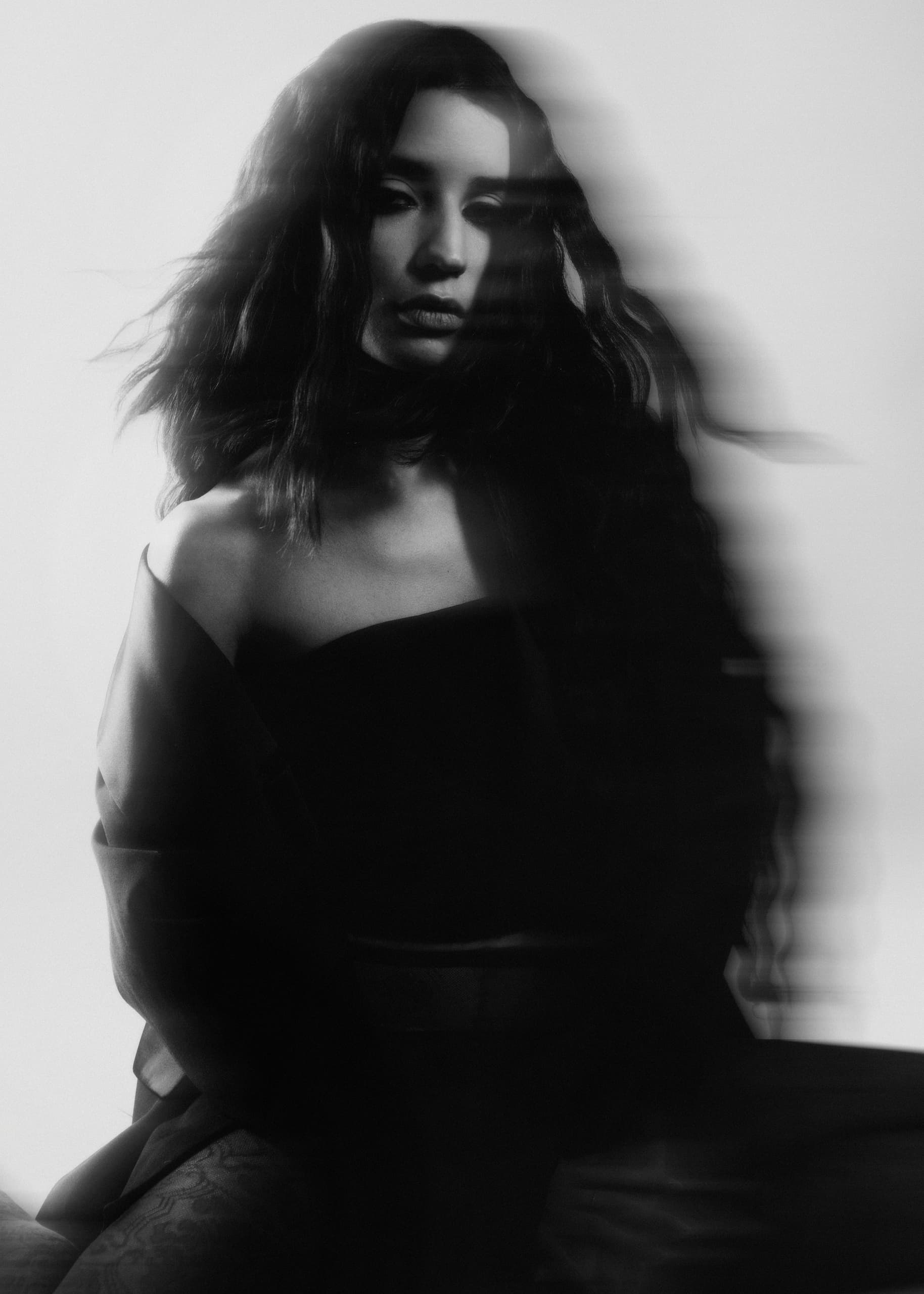 Mysterious woman in blurred black and white portrait, moody and enigmatic.