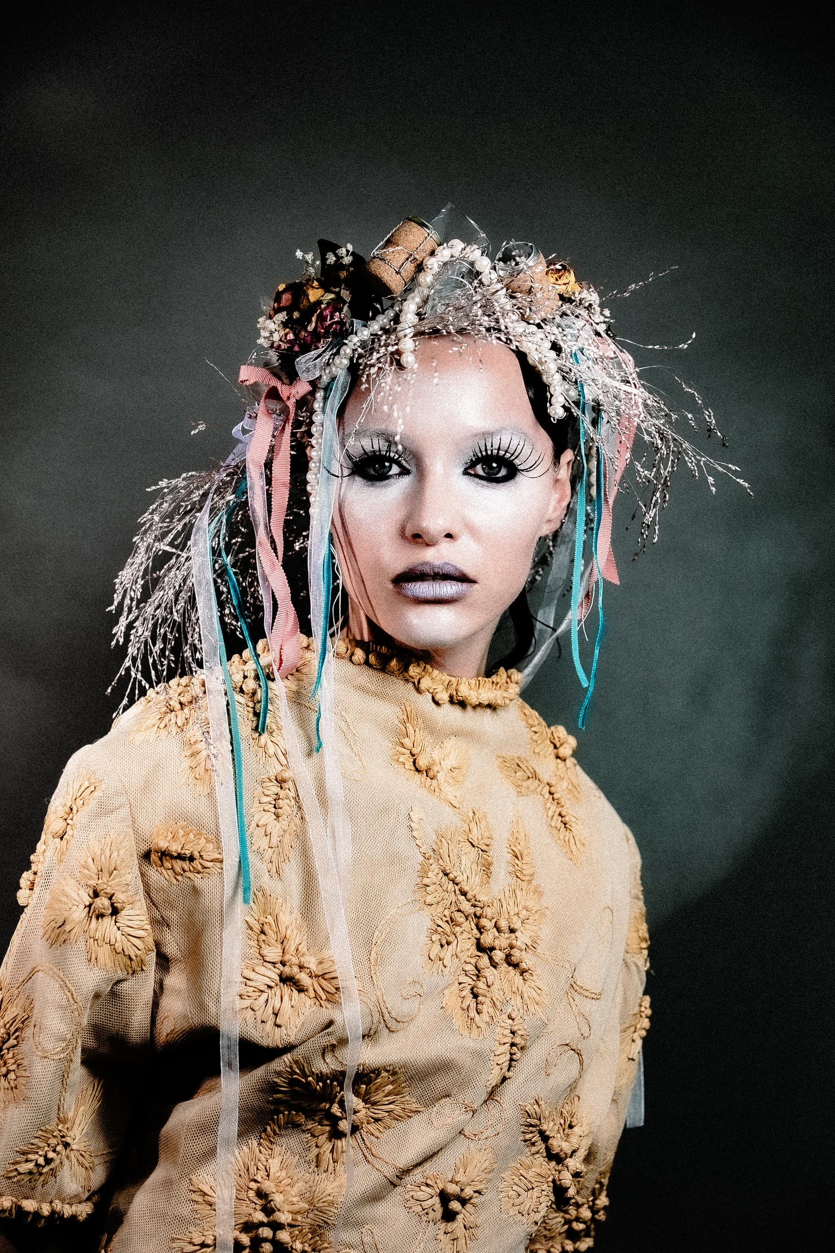 Portrait of a person in avant-garde floral attire with a vibrant headpiece.