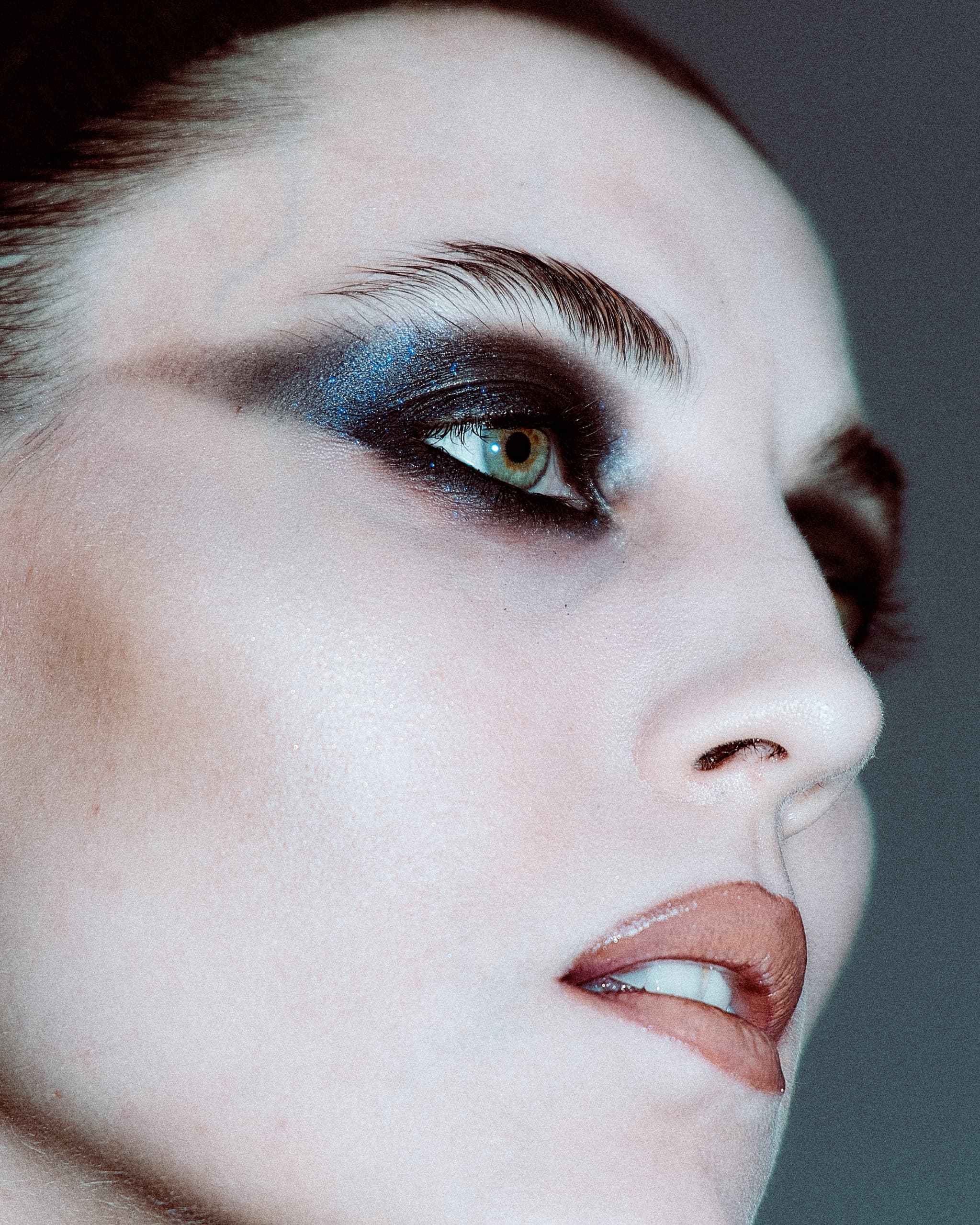 Close-up of bold blue and black eye makeup on model's face.