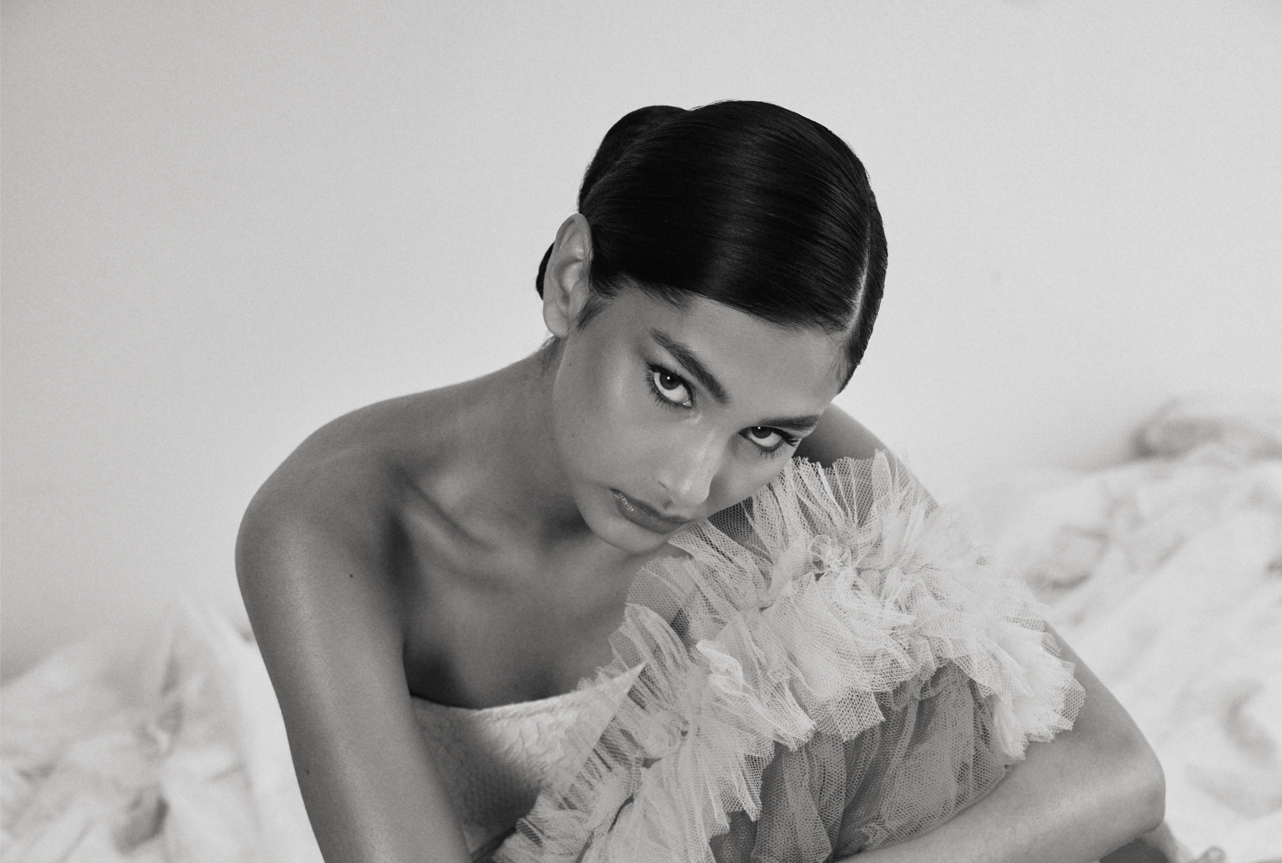 Elegant woman in a ruffled dress, monochrome fashion portrait.