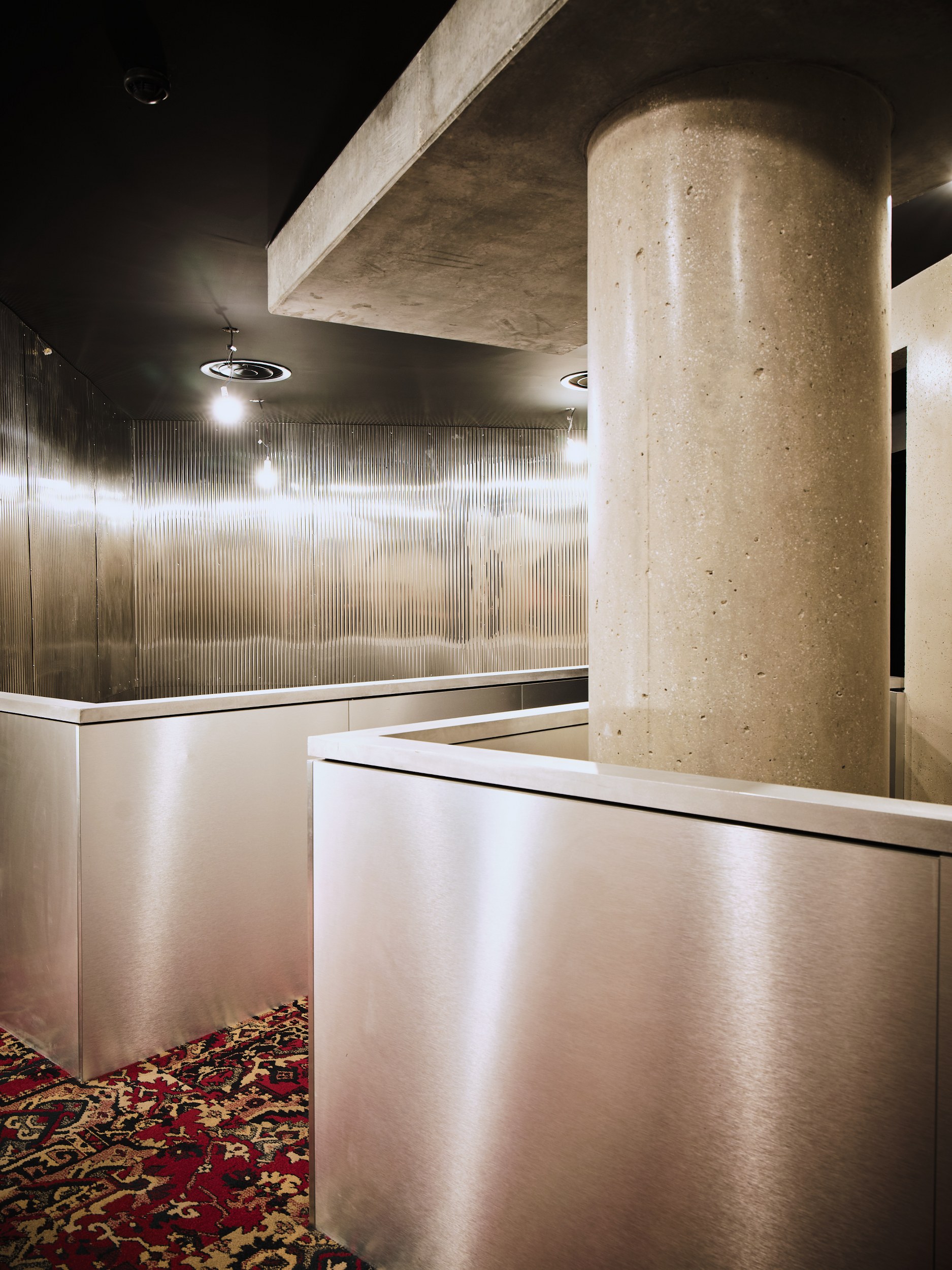 Modern industrial interior with metal panels and a large concrete pillar.