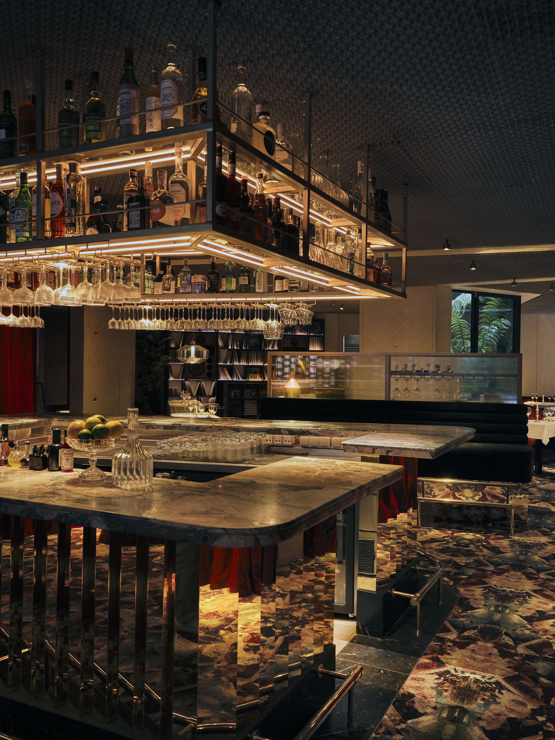 Luxurious bar interior with hanging shelves and elegant marble countertops.