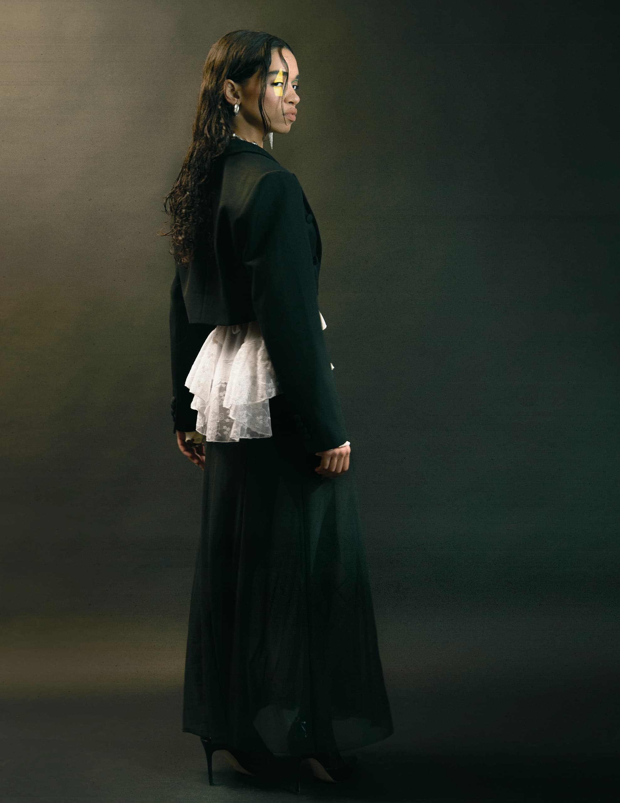 Elegant woman in black and white outfit, posing with a stylish look.