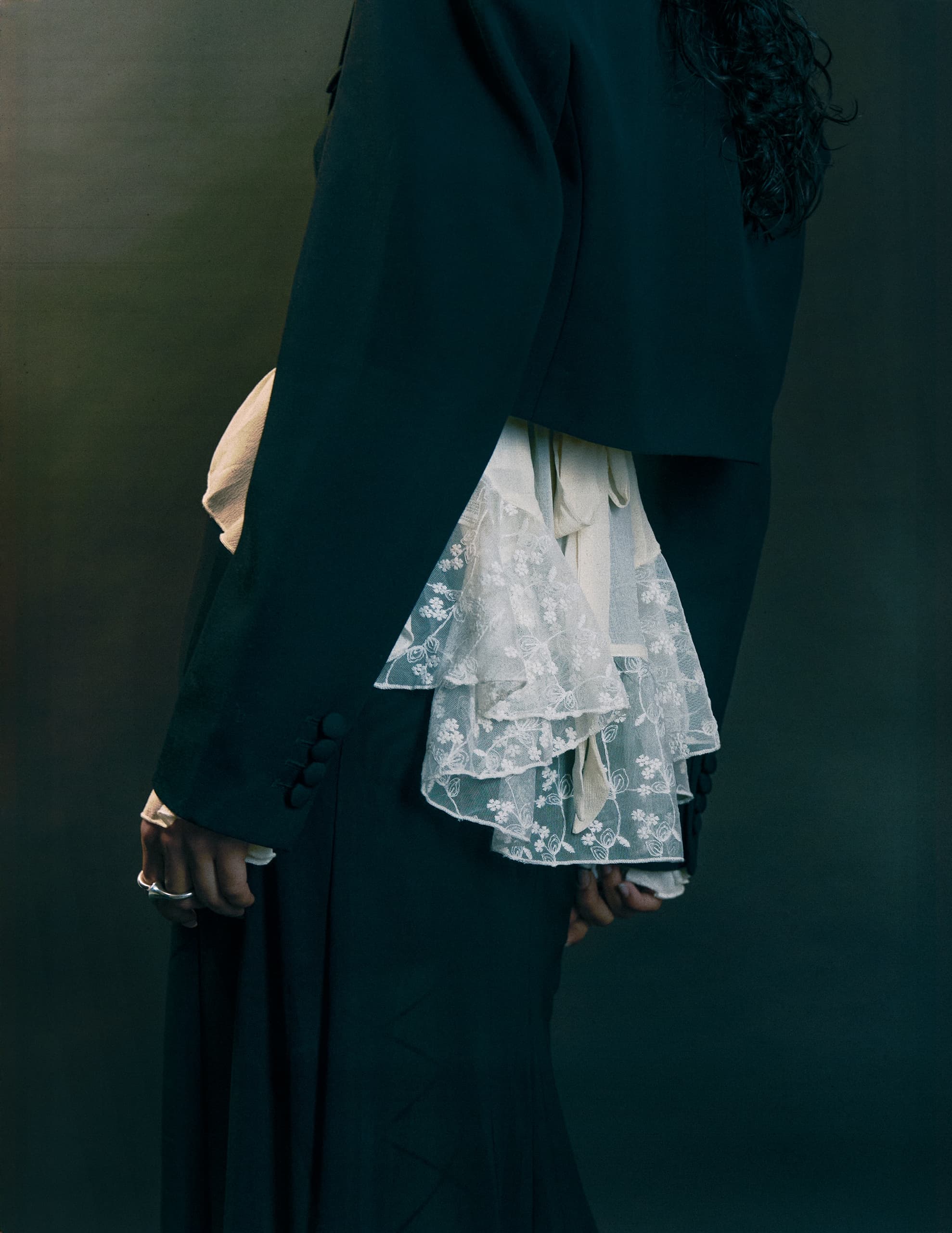 Elegant outfit with lace details and dark jacket, showcasing intricate fashion design.