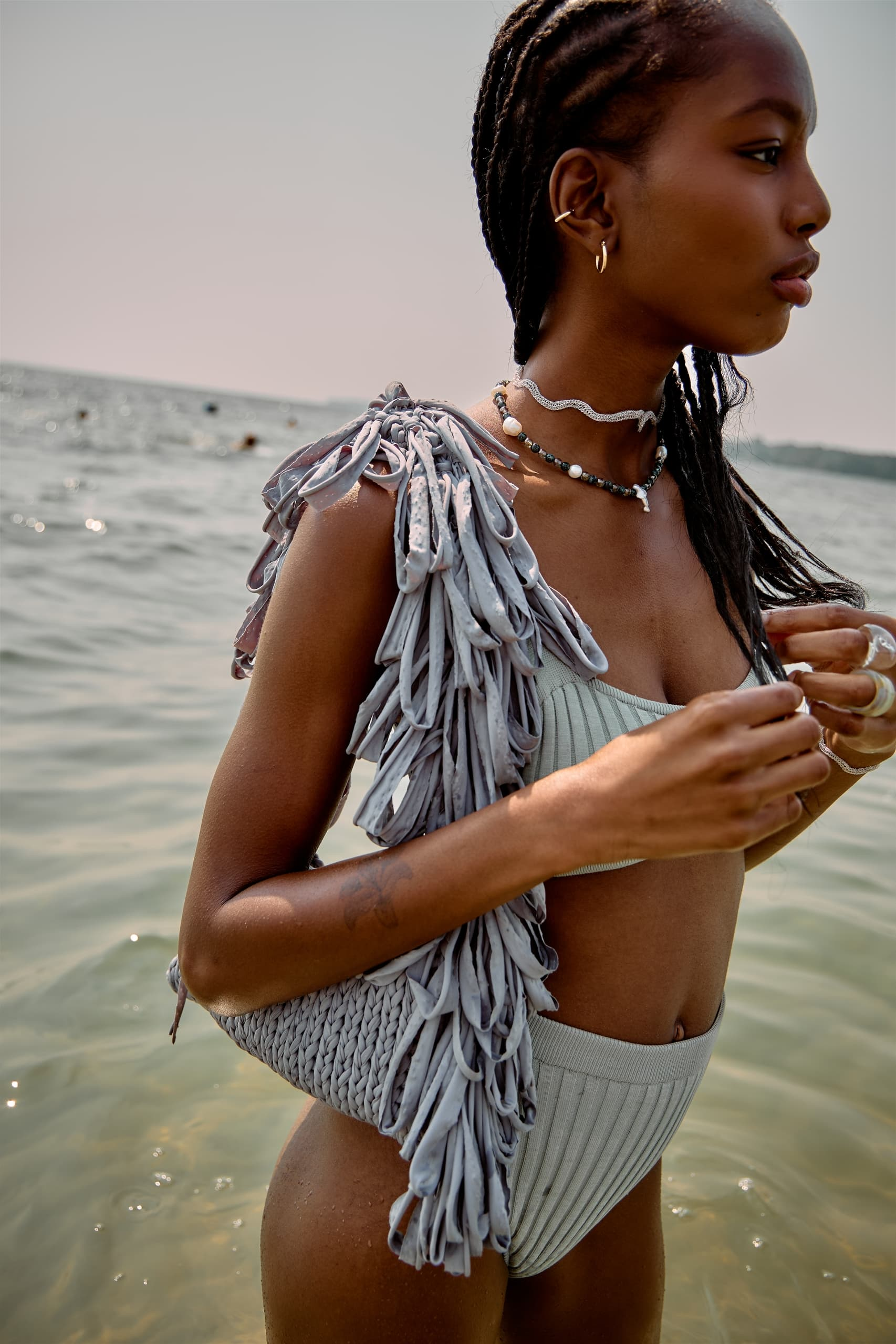 Woman in a stylish swimsuit enjoys a sunny day at the beach.