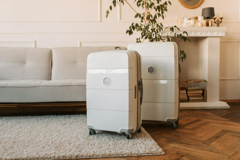 White suitcases in a stylish living room with cozy decor and carpet.
