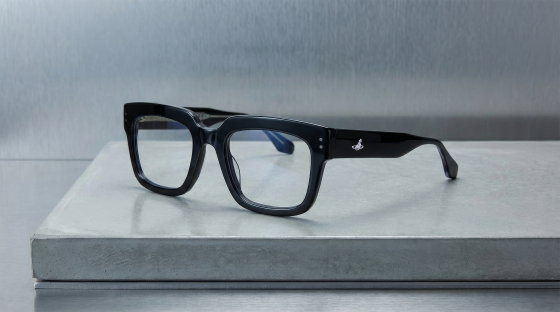 Black square eyeglasses on a gray surface, modern design.