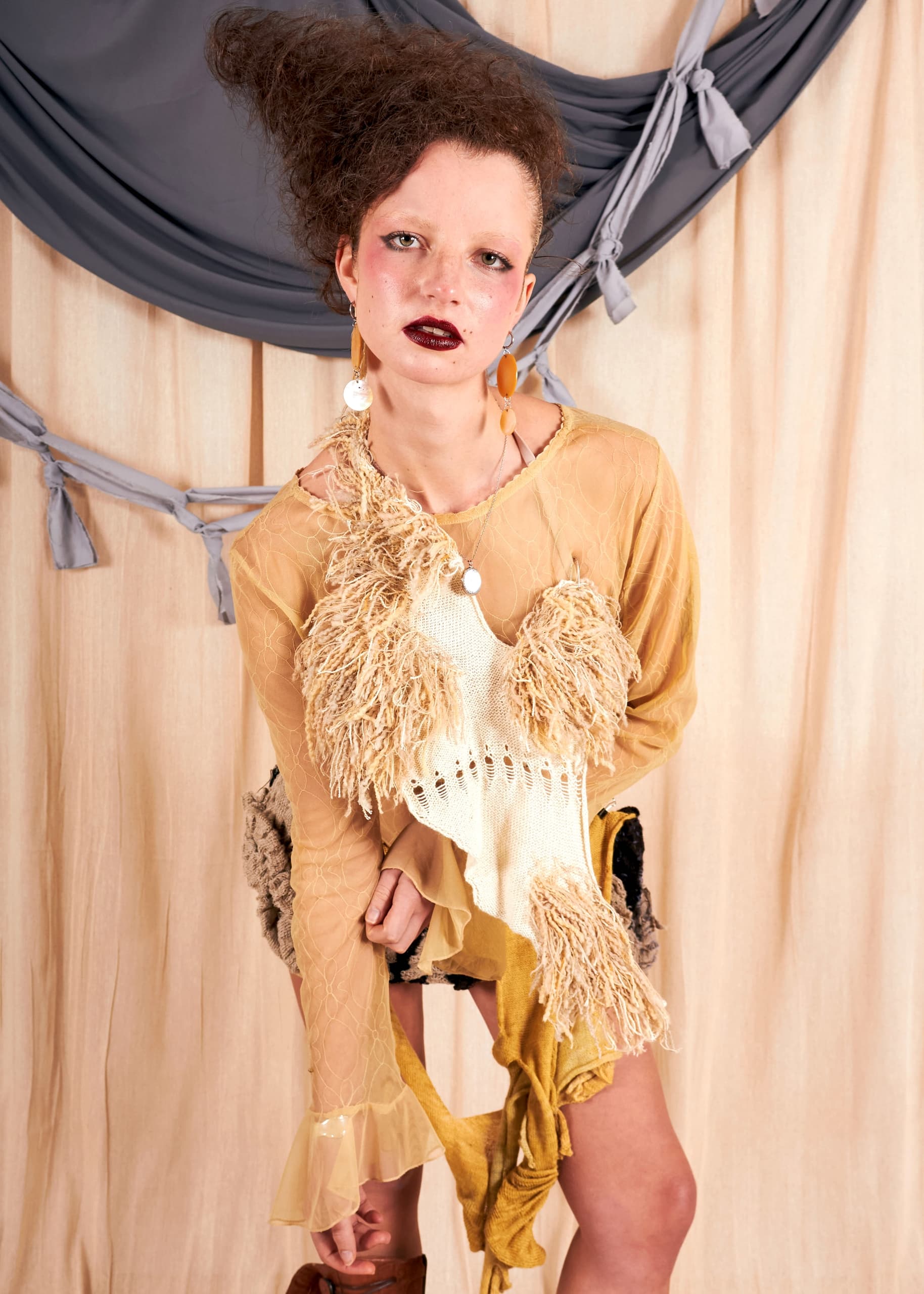 Person in elegant dress stands on balcony, looking up with a relaxed expression.