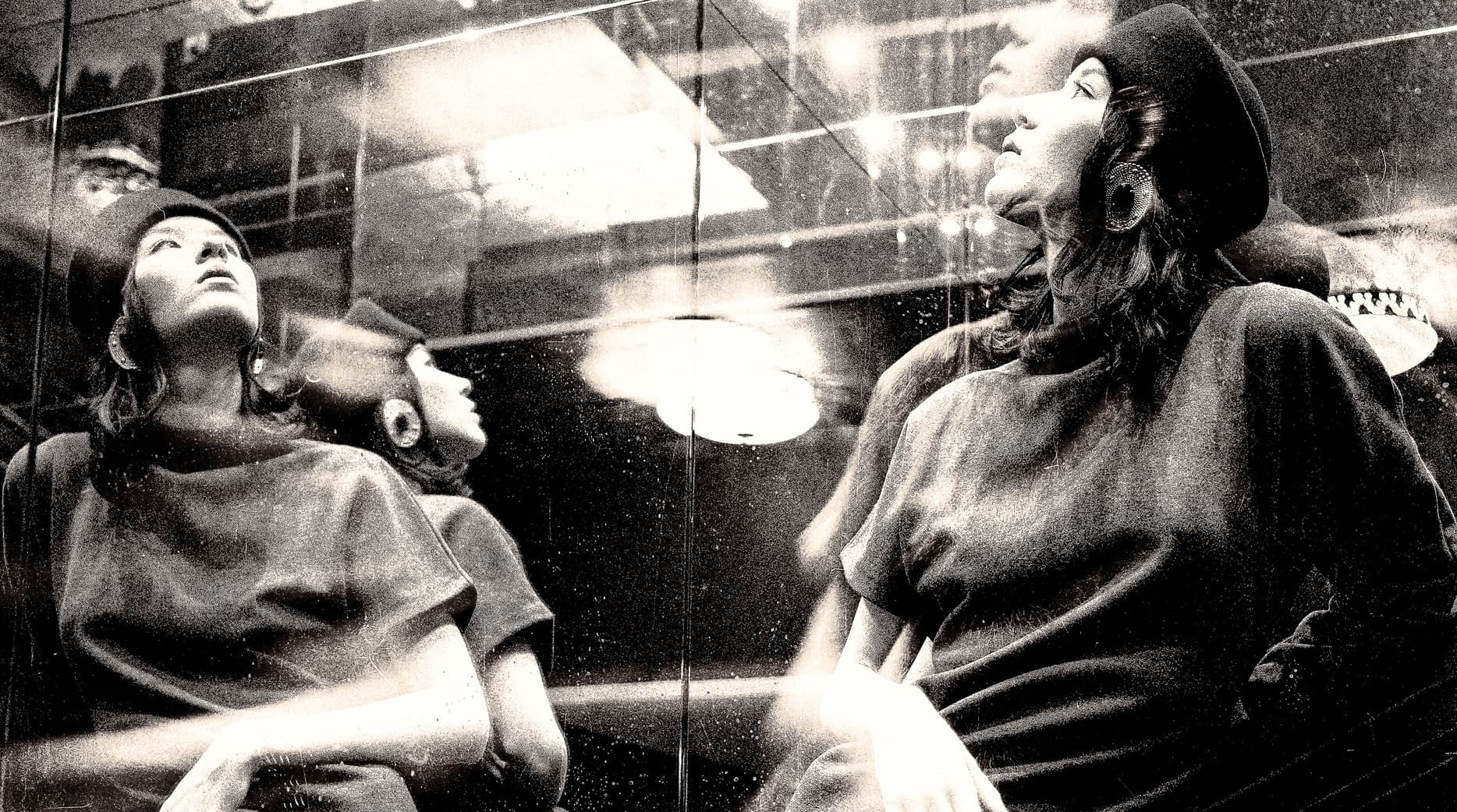 Elegant woman in beret reflected in artistic, mirrored photography.