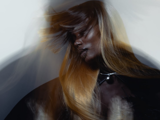 Woman with flowing hair in motion, dreamy blur effect, artistic portrait.