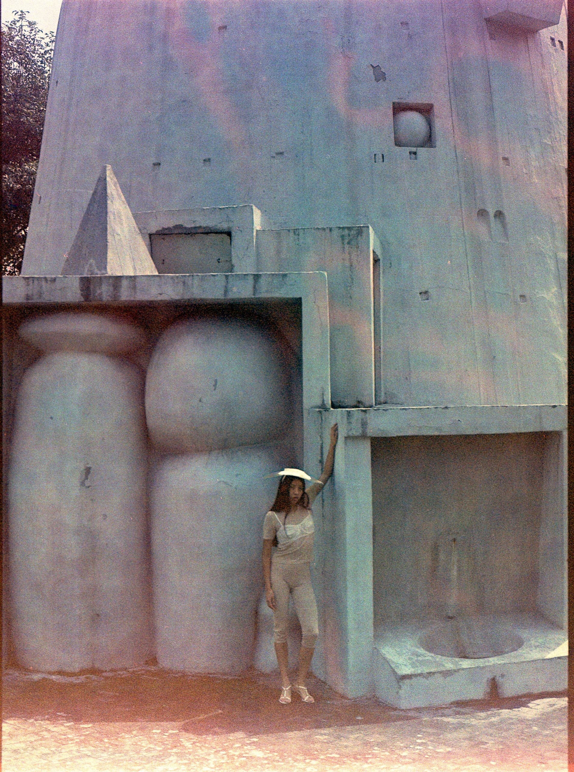 Person in front of large, abstract concrete structure with geometric shapes.