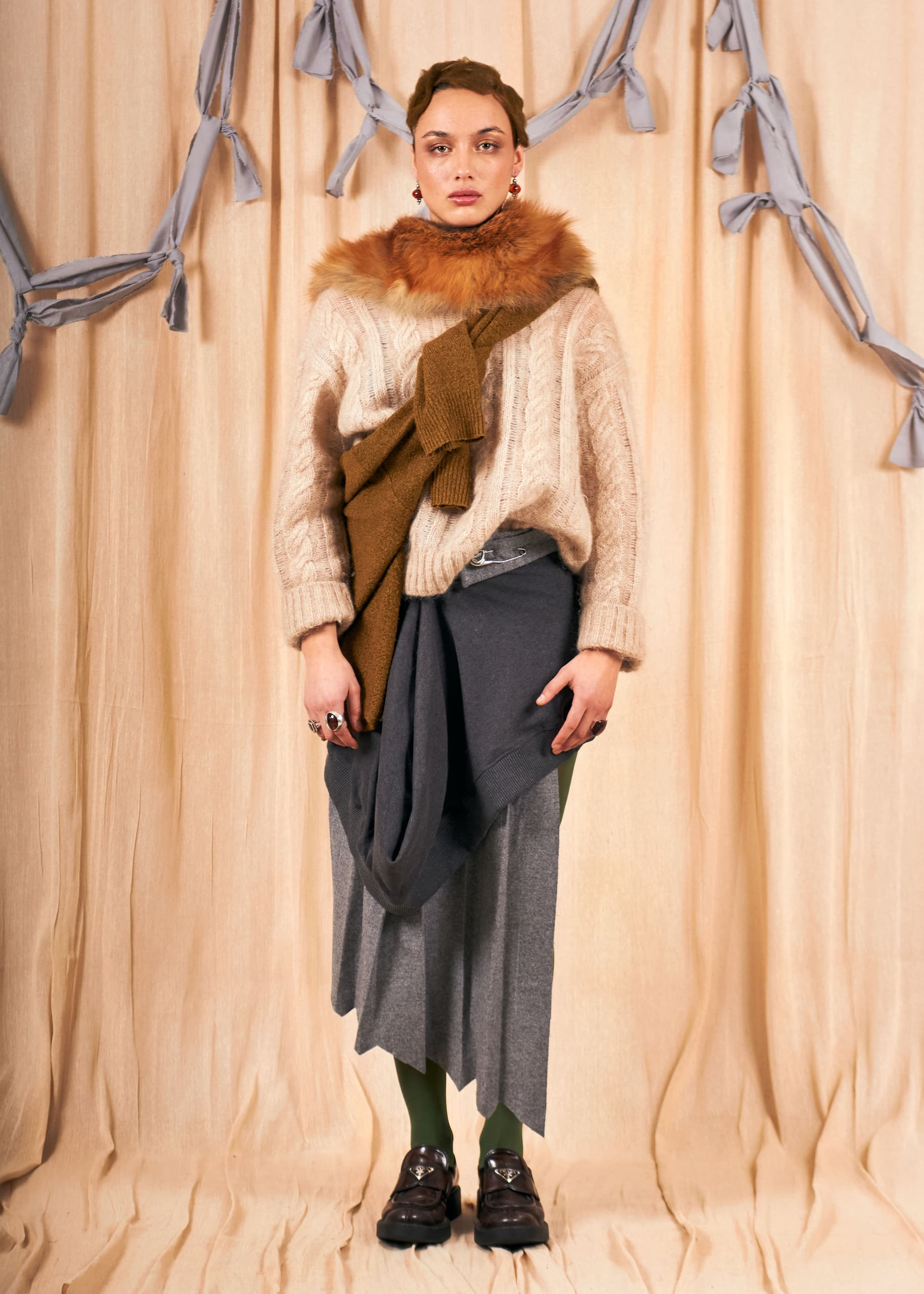 Fashionable woman in layered winter outfit with neutral tones.