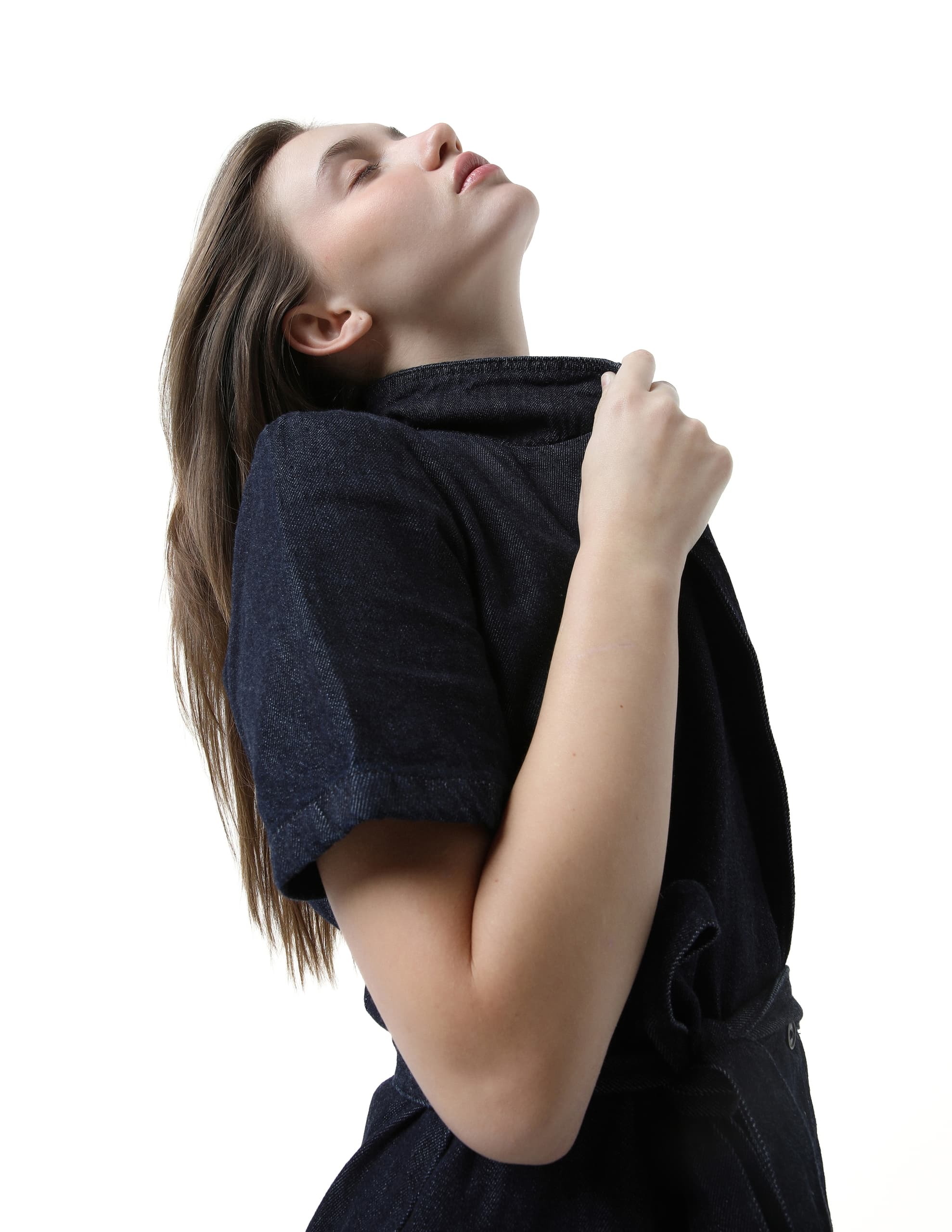 Woman in denim outfit posing against a plain white background.