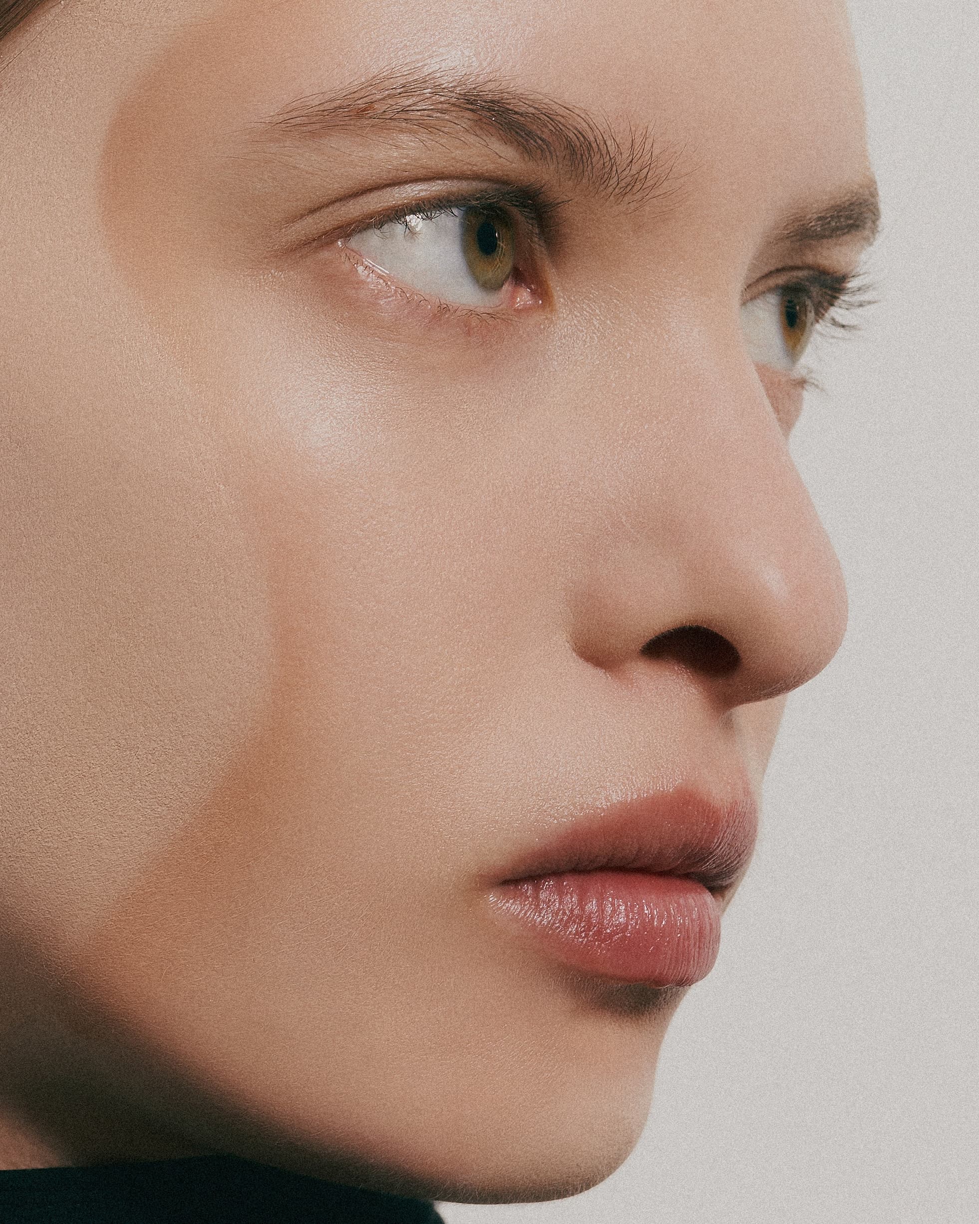 Close-up of a person's face with smooth skin and natural makeup.