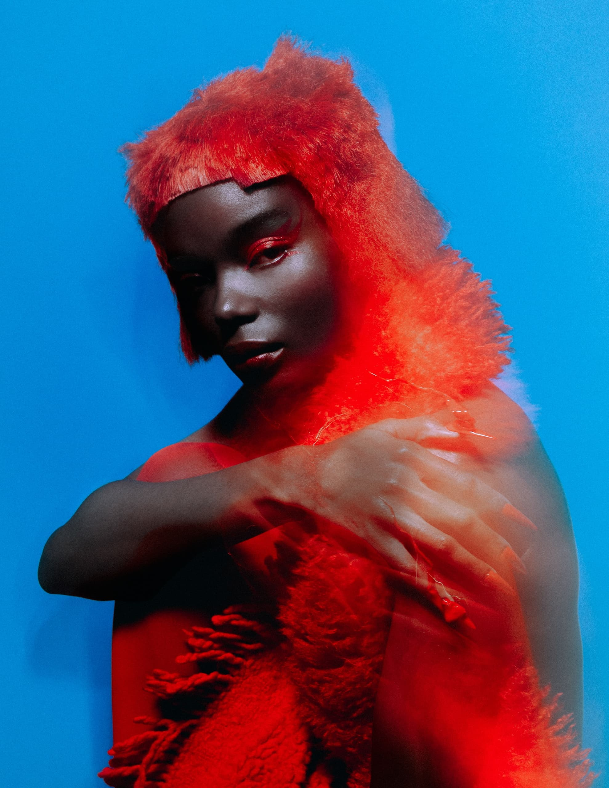 Vibrant portrait with red fur and blue background, artistic blur effect.