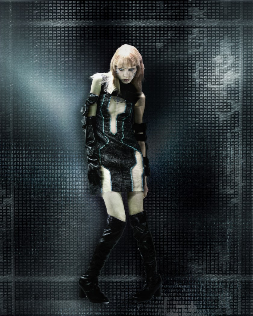 Futuristic fashion model in a sleek outfit with a digital grid background.