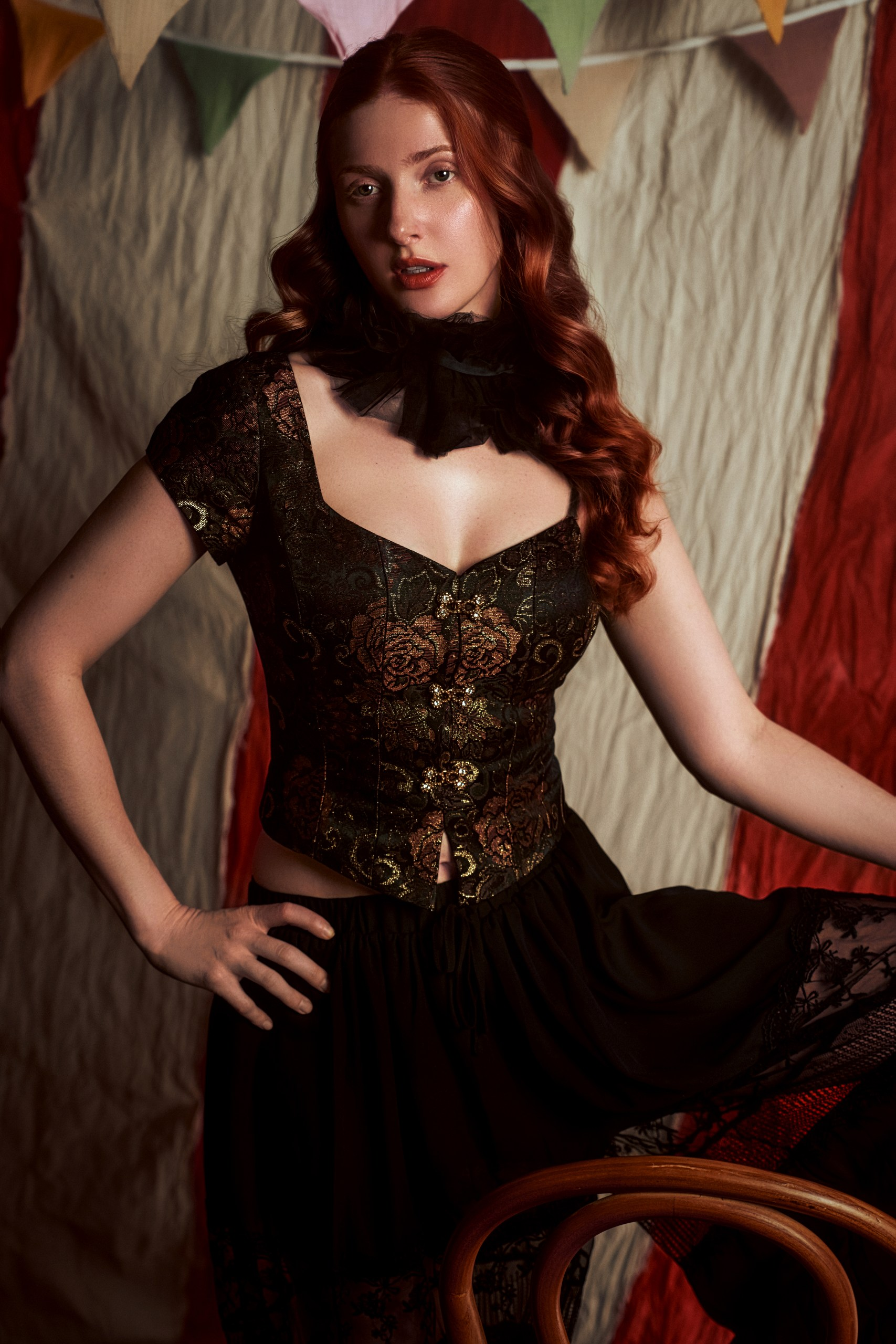 Vintage-inspired woman in a corset dress amidst colorful bunting décor.