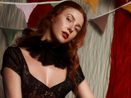 Woman in vintage attire with carnival bunting backdrop.