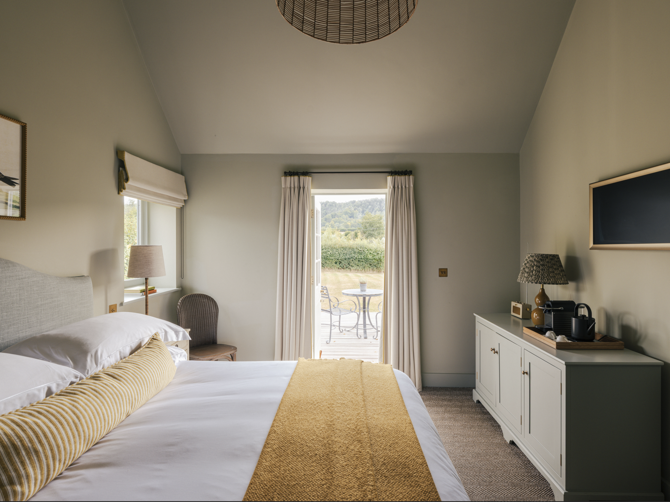 Cozy bedroom with outdoor view, featuring elegant decor and natural lighting.