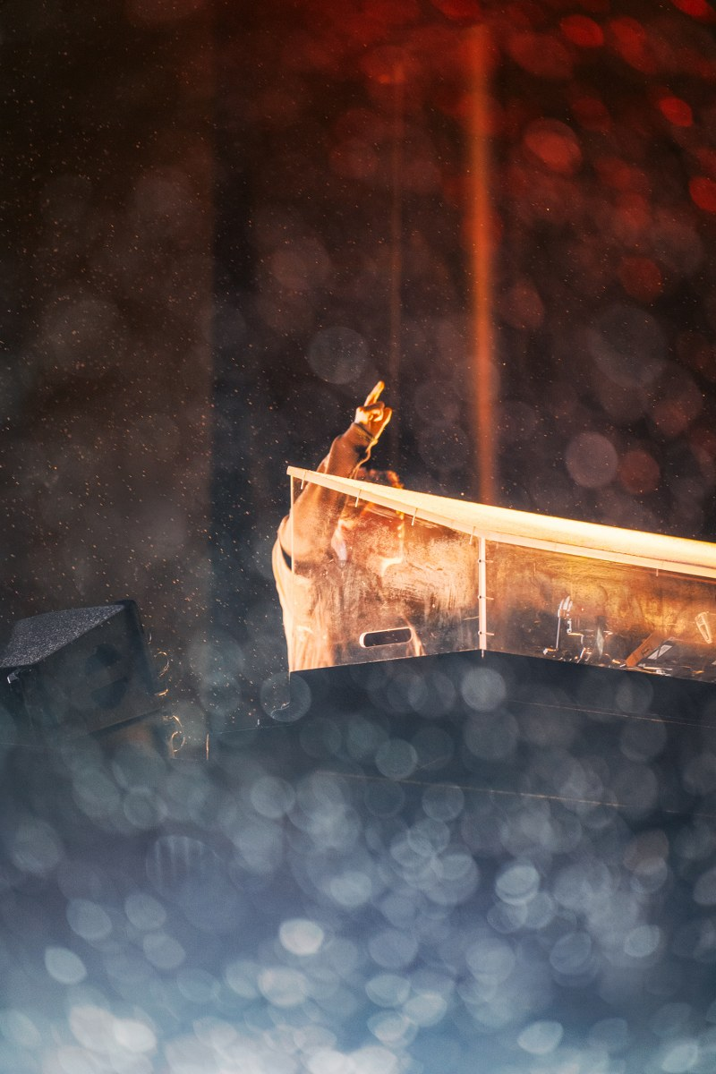 DJ performing live on stage with dynamic lighting and vibrant atmosphere.