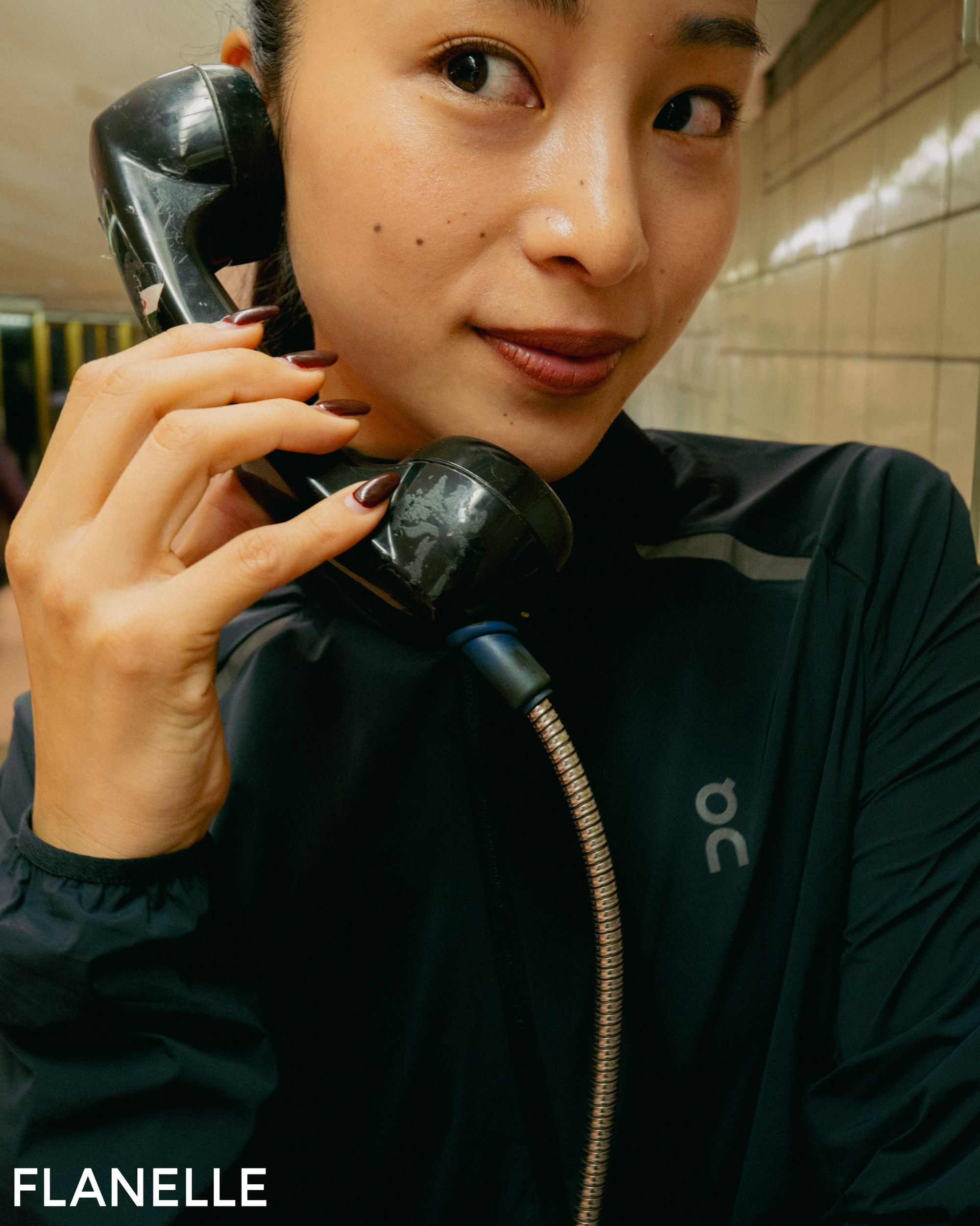 Person talking on a vintage phone in urban setting.