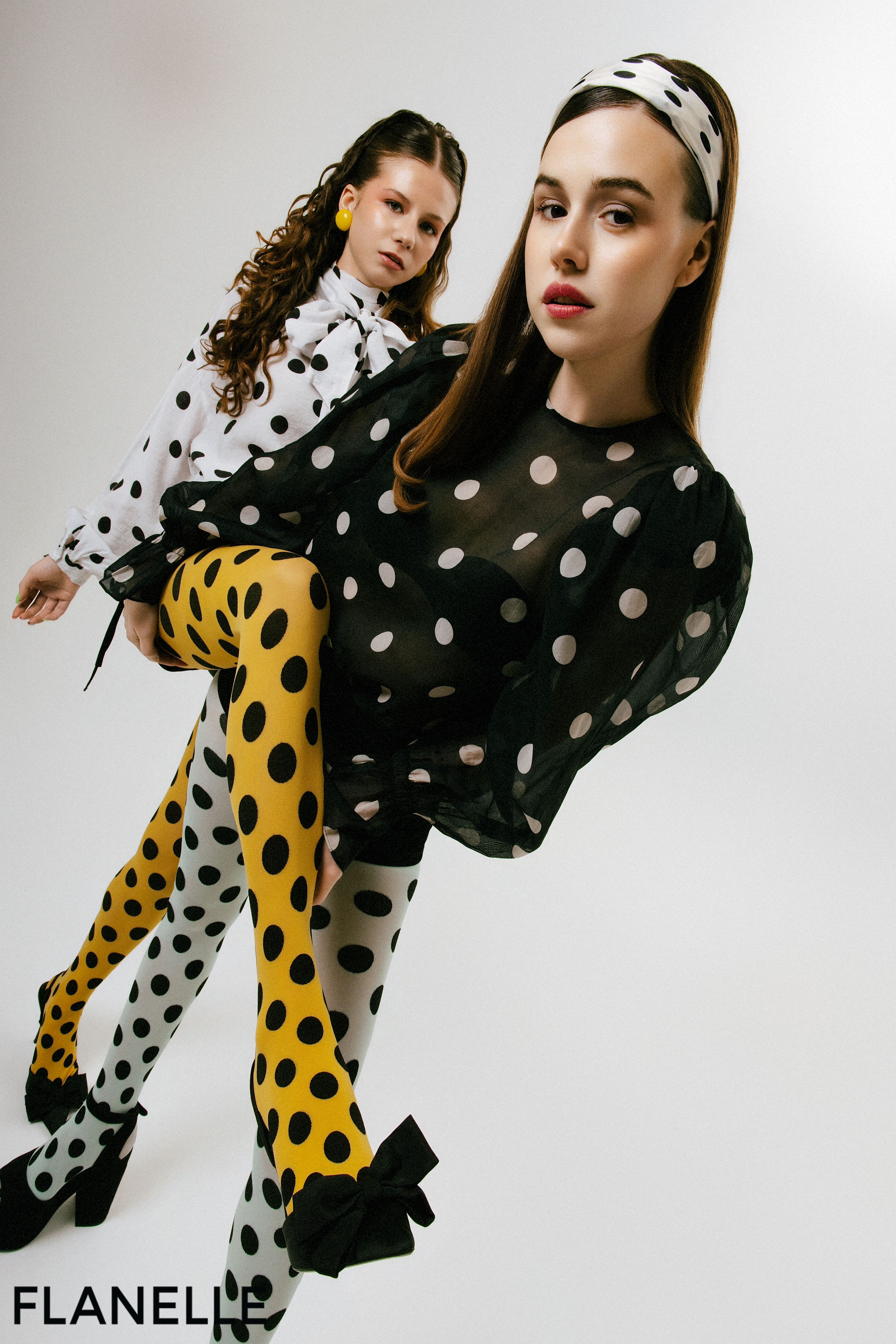 Fashion models in stylish polka dot outfits with playful poses.