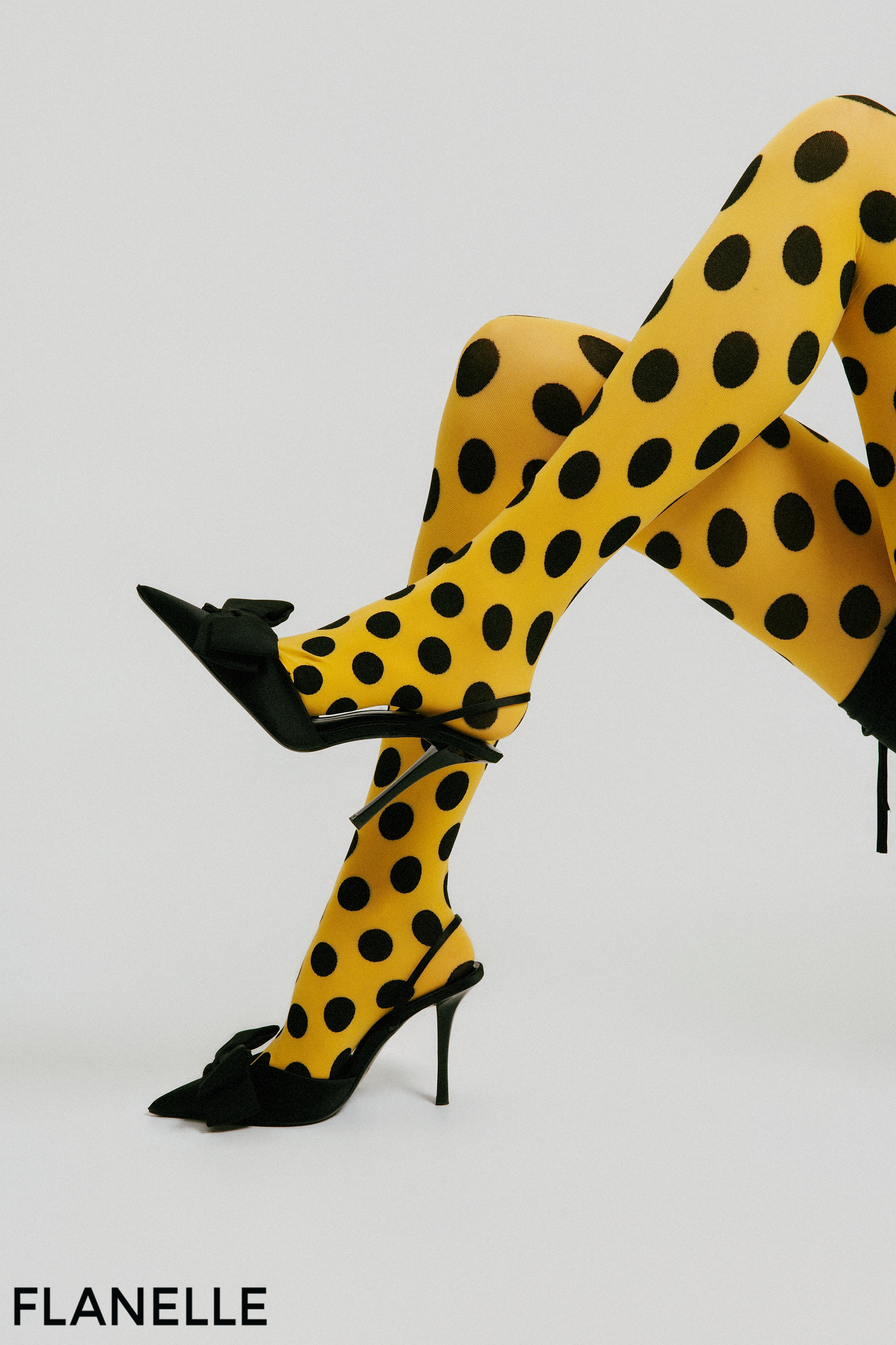 Yellow polka dot tights and black heels for a bold, fashionable look.