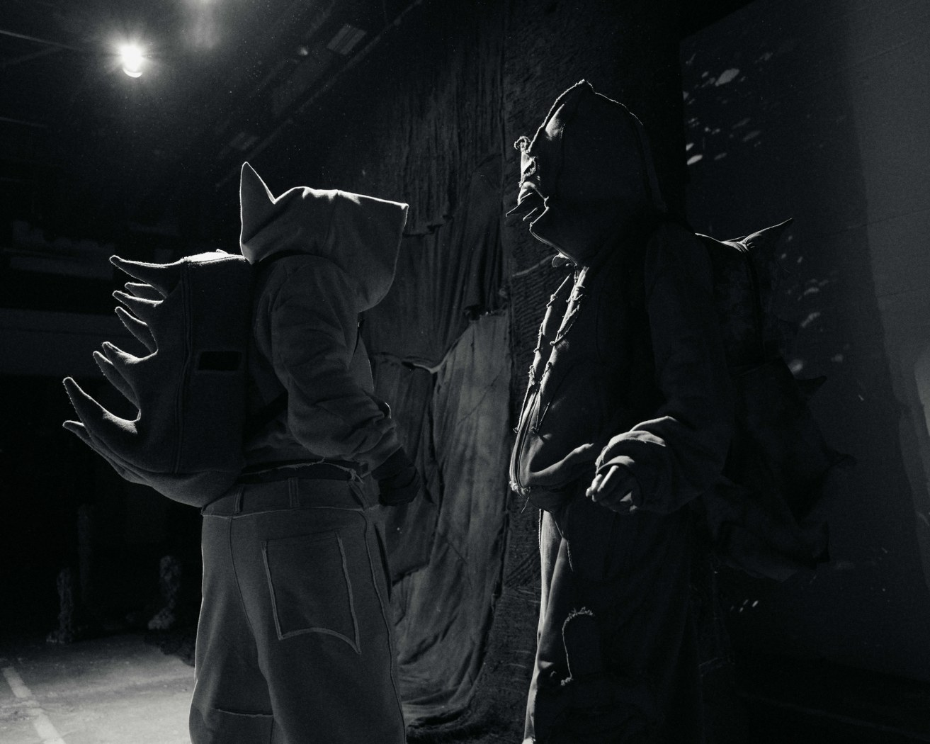 Two figures in spiky costumes face each other in dramatic lighting.