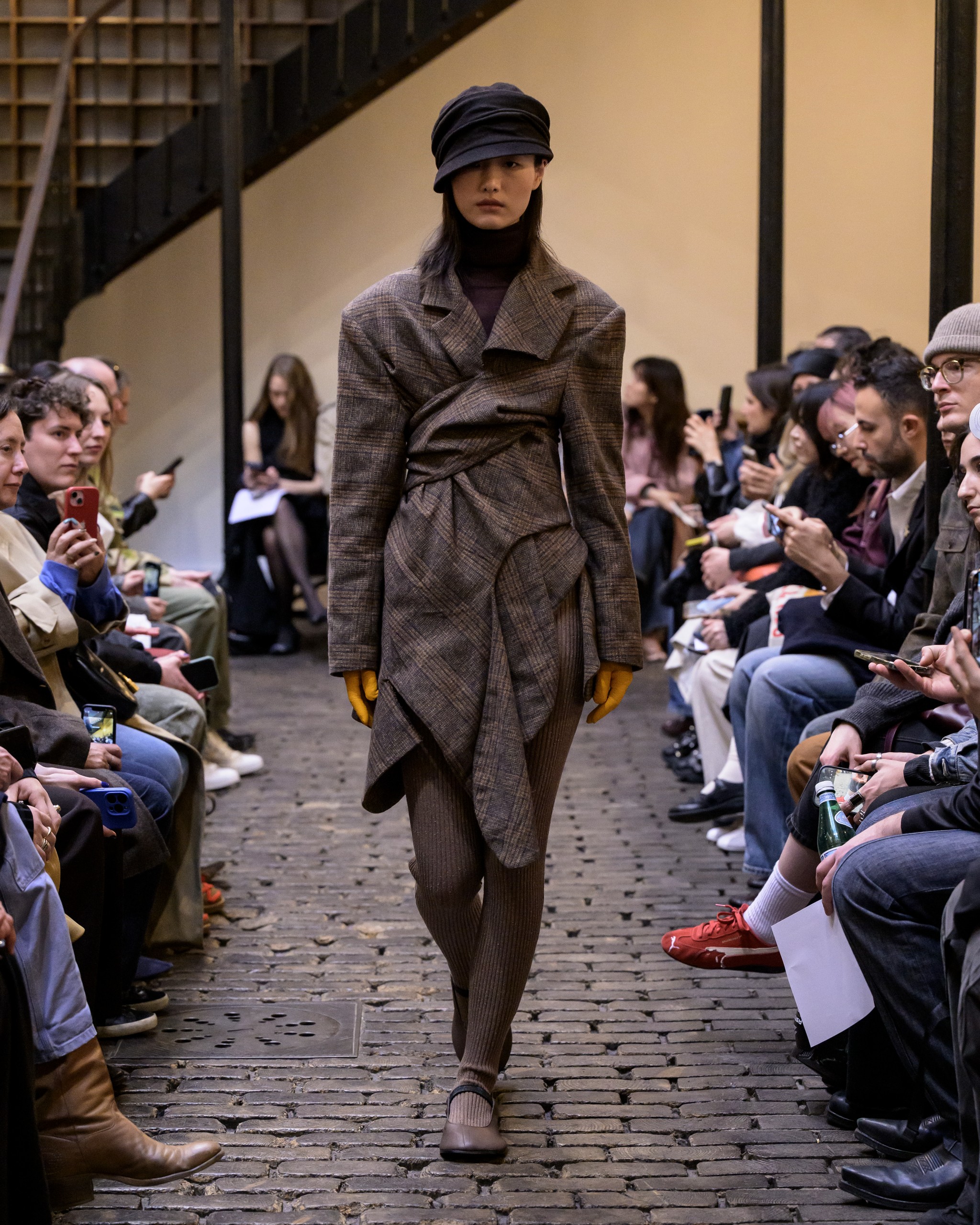 Model showcases fashion-forward outfit at runway show.