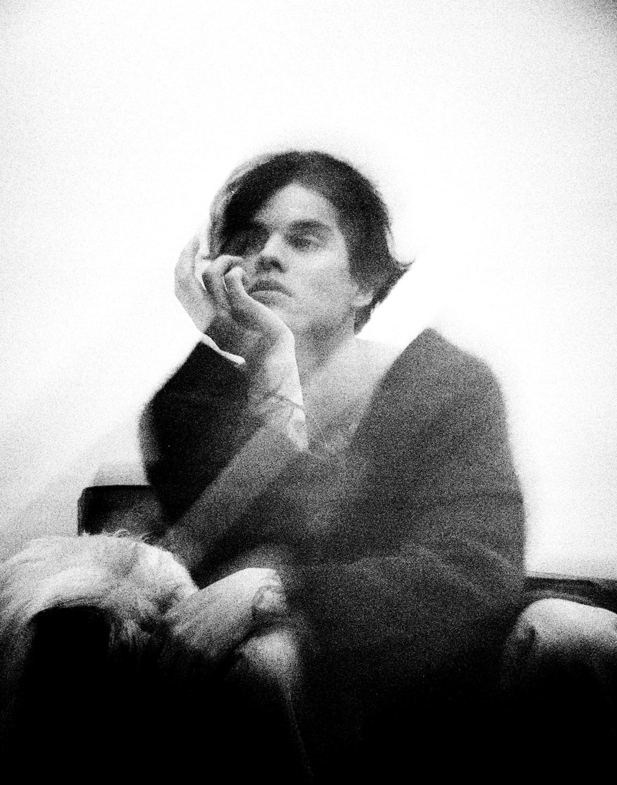 Abstract black and white portrait of a thoughtful person in a blurred setting.