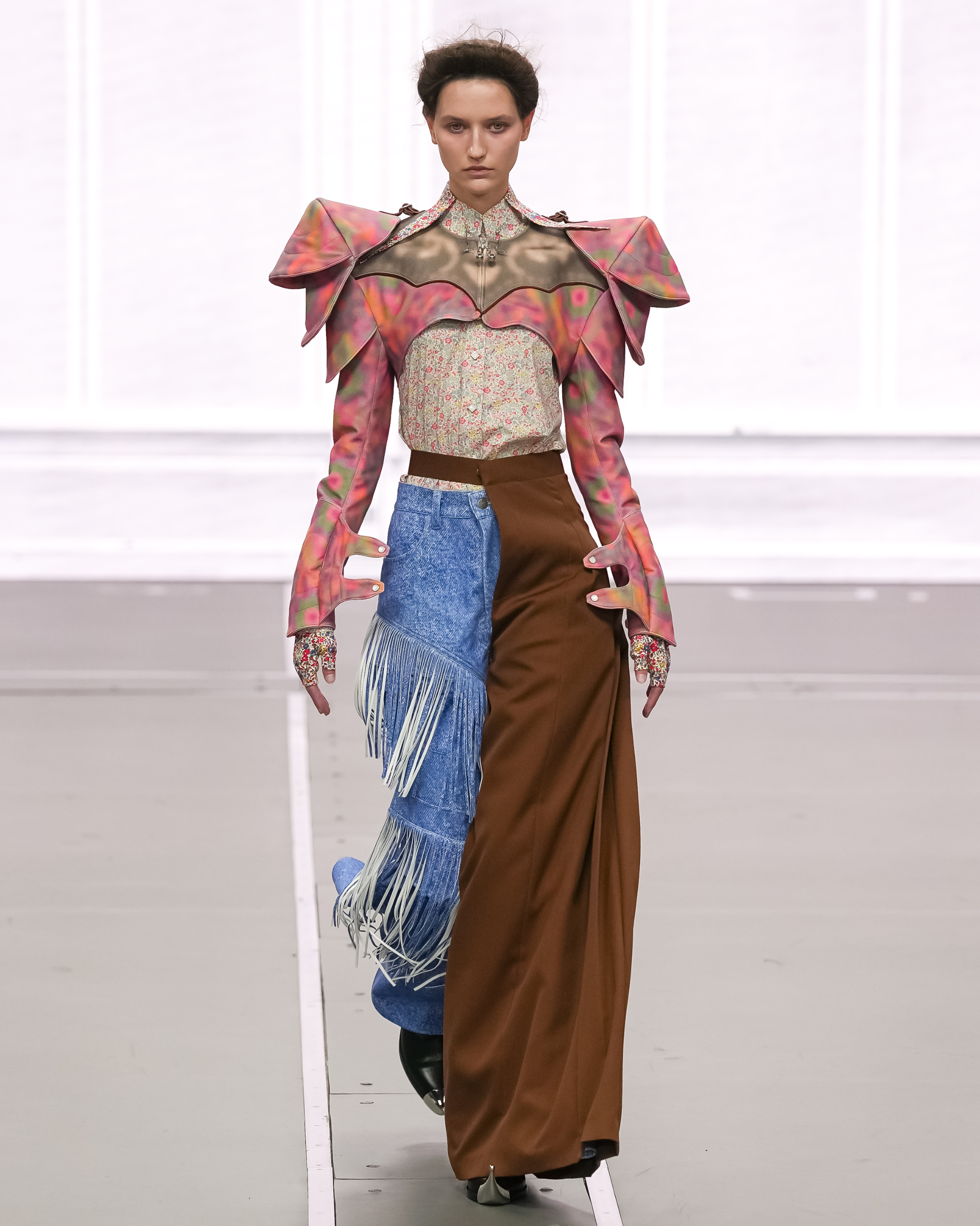 Avant-garde fashion runway look with colorful jacket and asymmetrical pants.