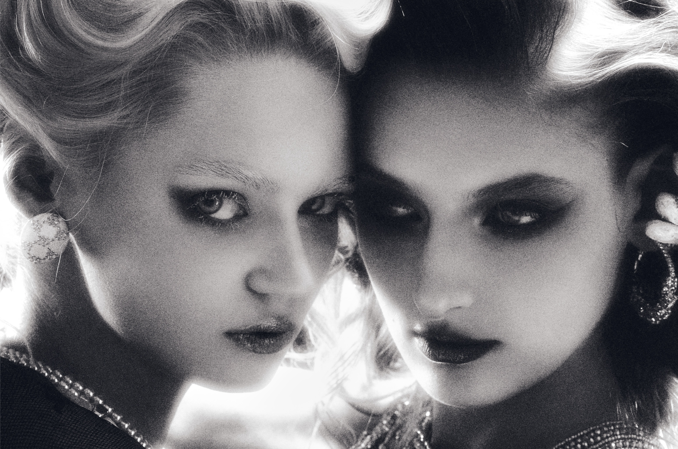 Artistic fashion portrait of two women, dramatic lighting, elegant jewelry.