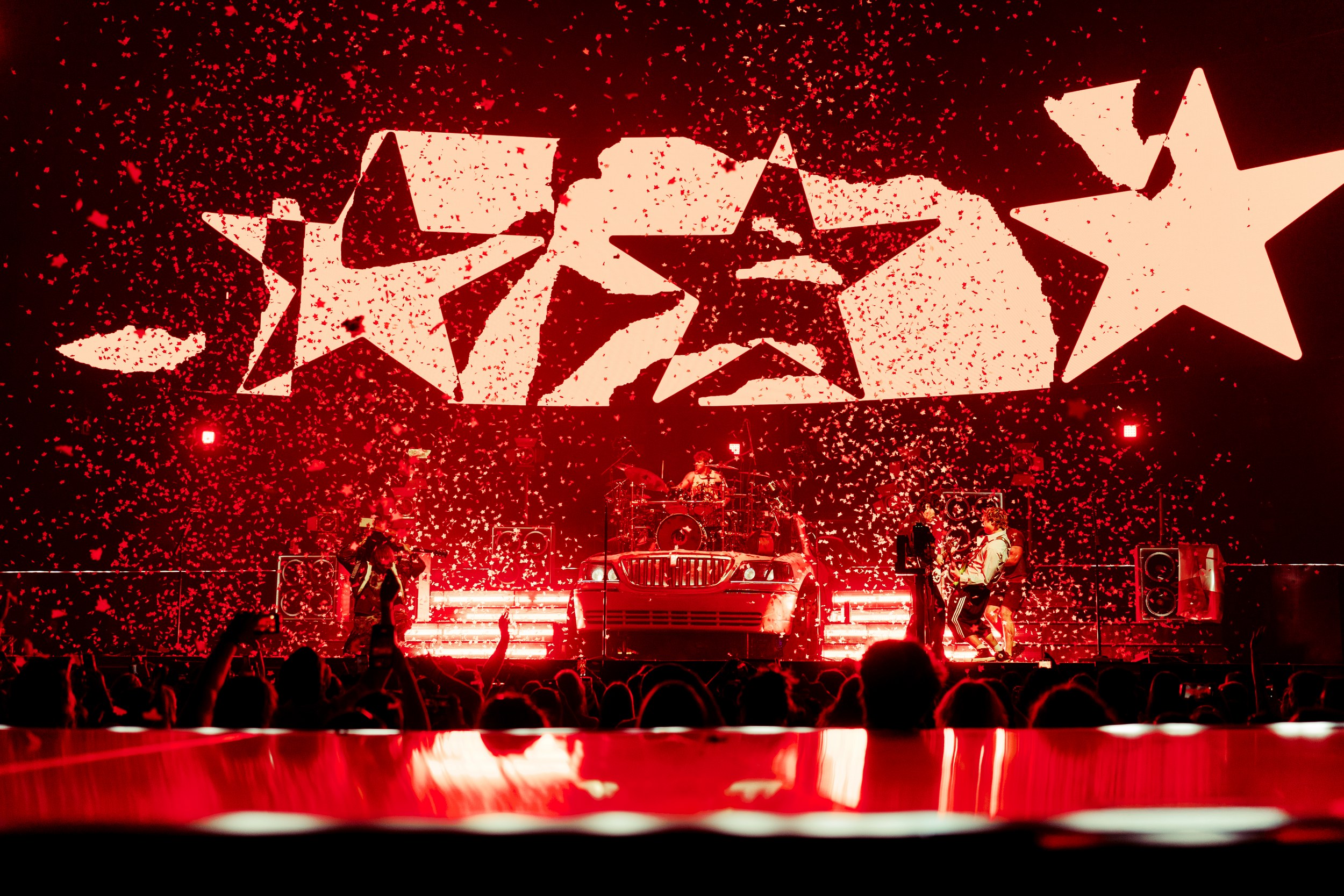 Rock concert with dynamic red stage lighting and star visuals.