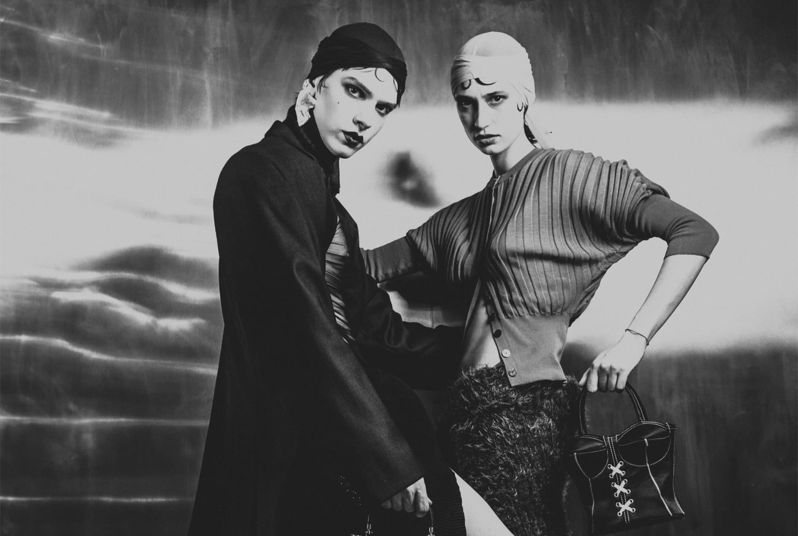 Fashionable duo striking a pose in monochrome elegance.