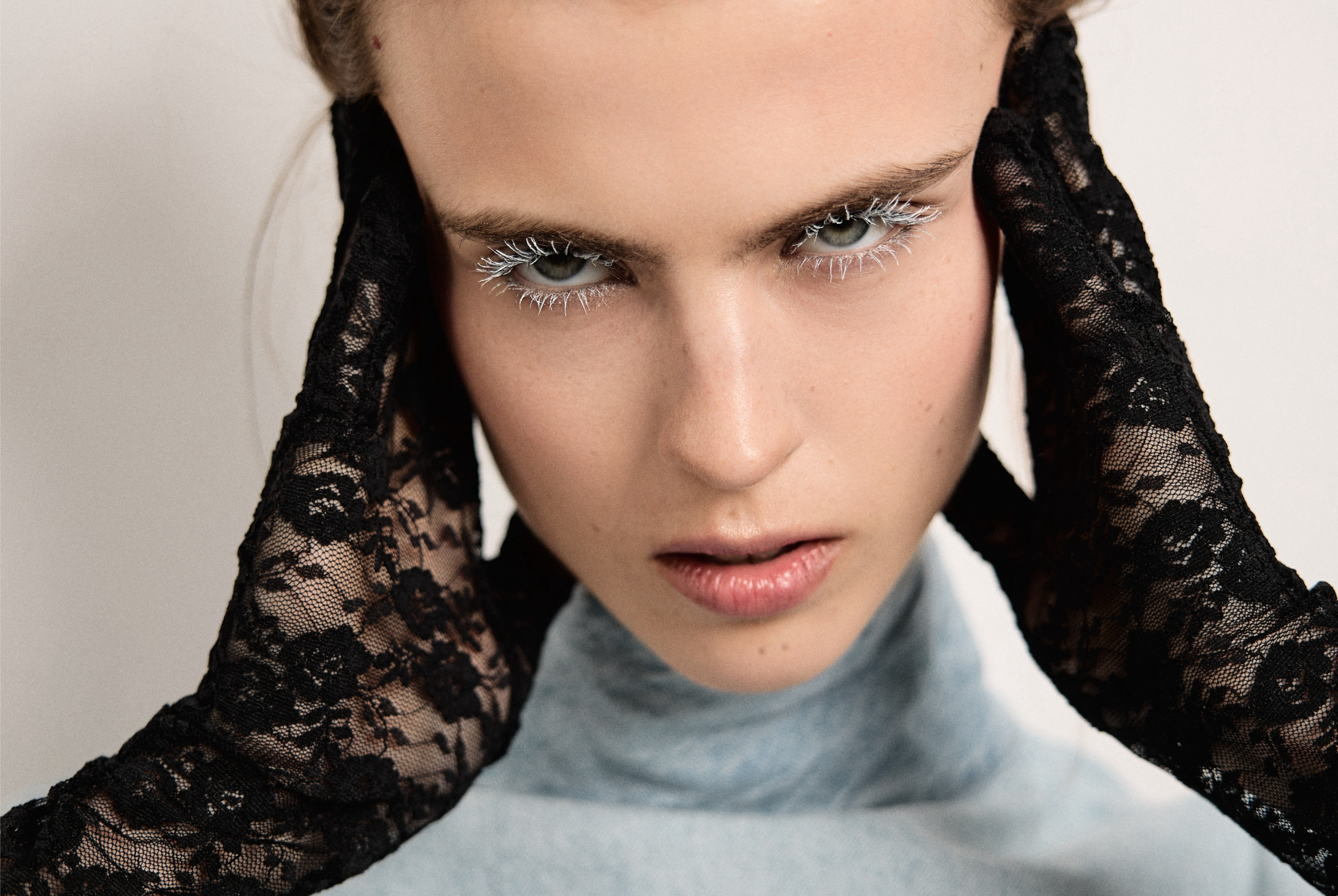 Fashion portrait with black lace gloves and dramatic eye makeup.