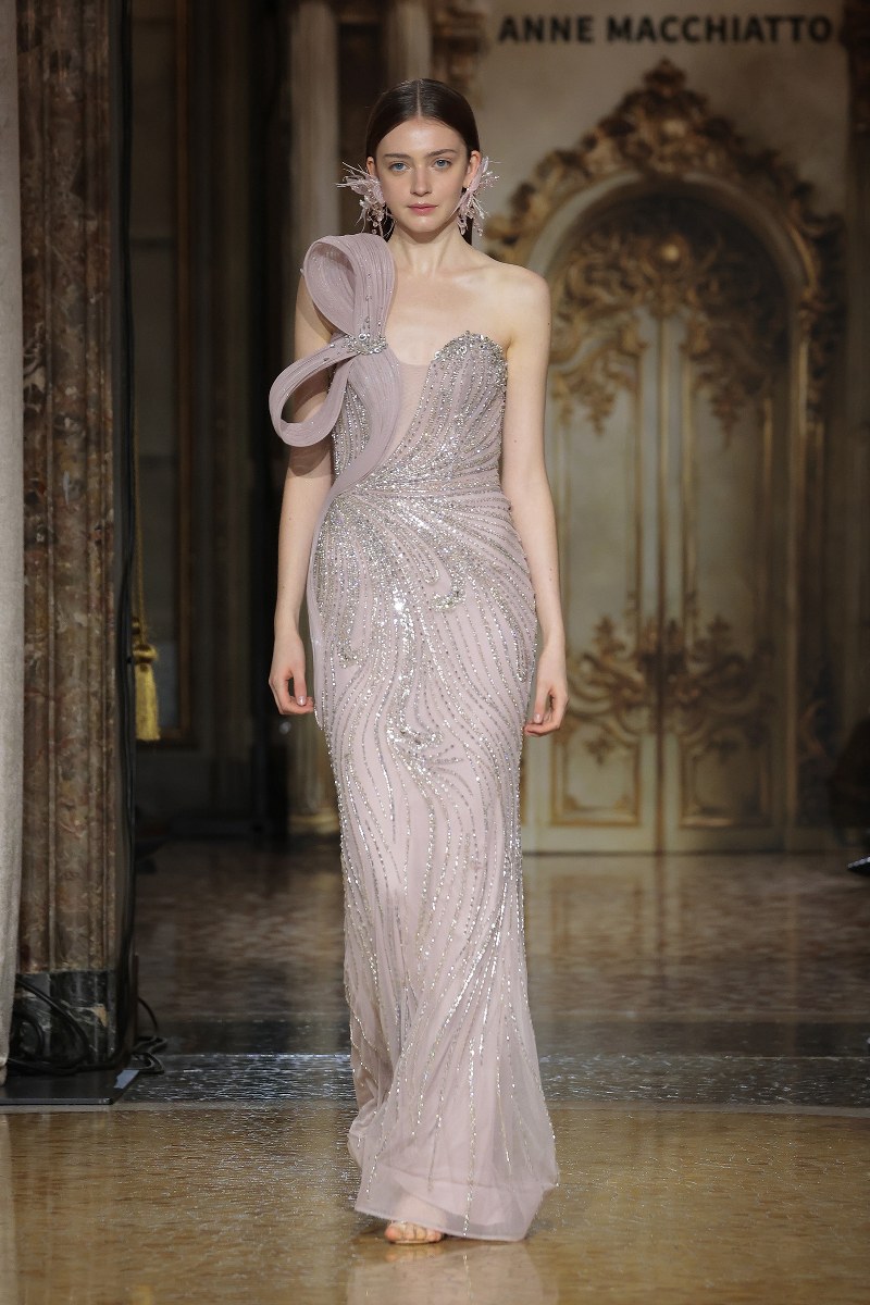 Model in a shimmering evening gown on a luxurious runway.